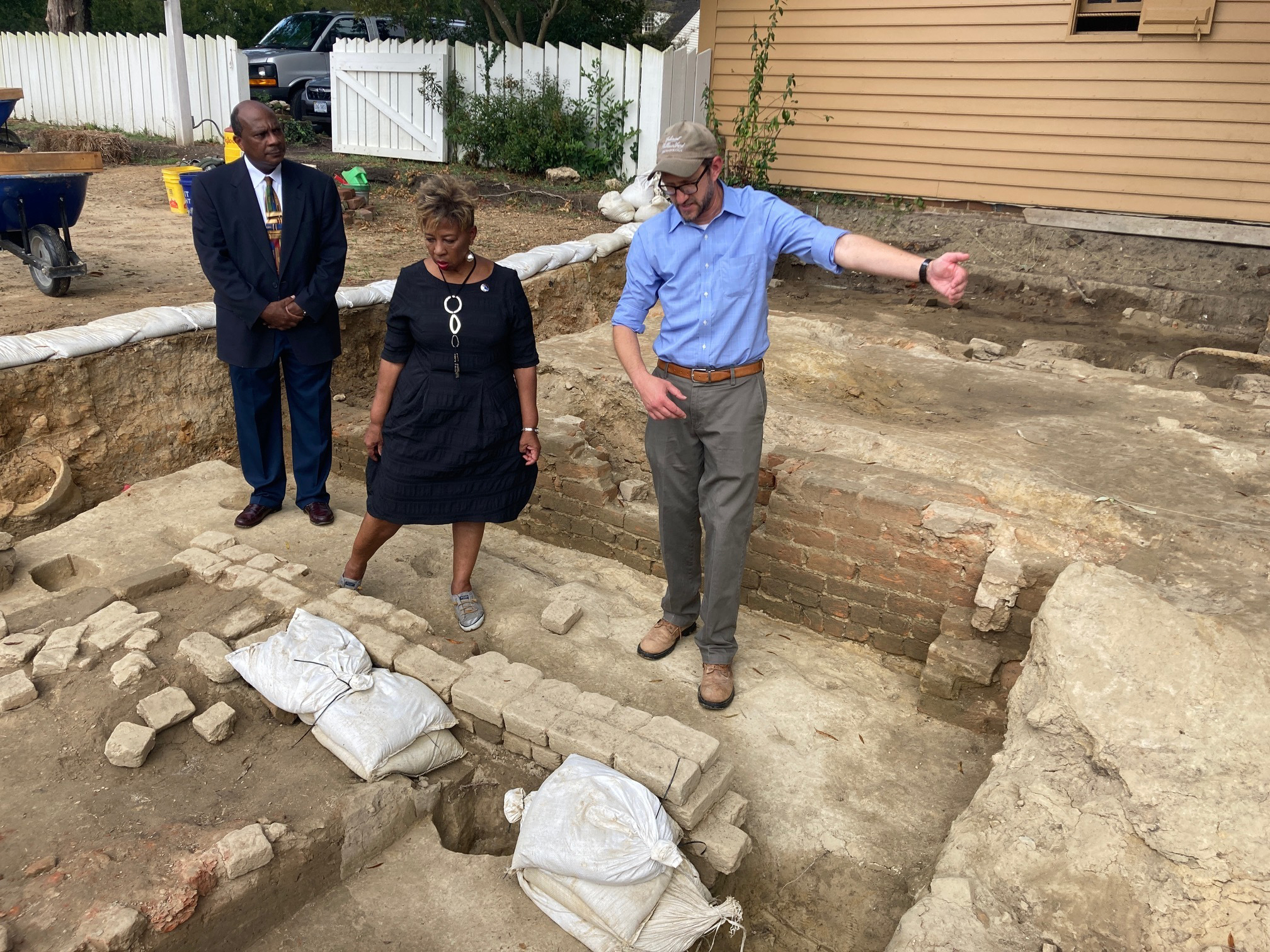 FILE - From left, Reginald F. Davis, pastor of First Baptist Church, Connie Matthews Harshaw, a member of First Baptist, and Jack Gary, Colonial Williamsburg's director of archaeology, stand at the brick-and-mortar foundation of one the oldest Black churches in the U.S. on Oct. 6, 2021, in Williamsburg, Va. Experts announced Thursday, April 6, 2023, that three men whose graves were found at the site were members of the church in the early 19th Century. (AP Photo/Ben Finley, File)