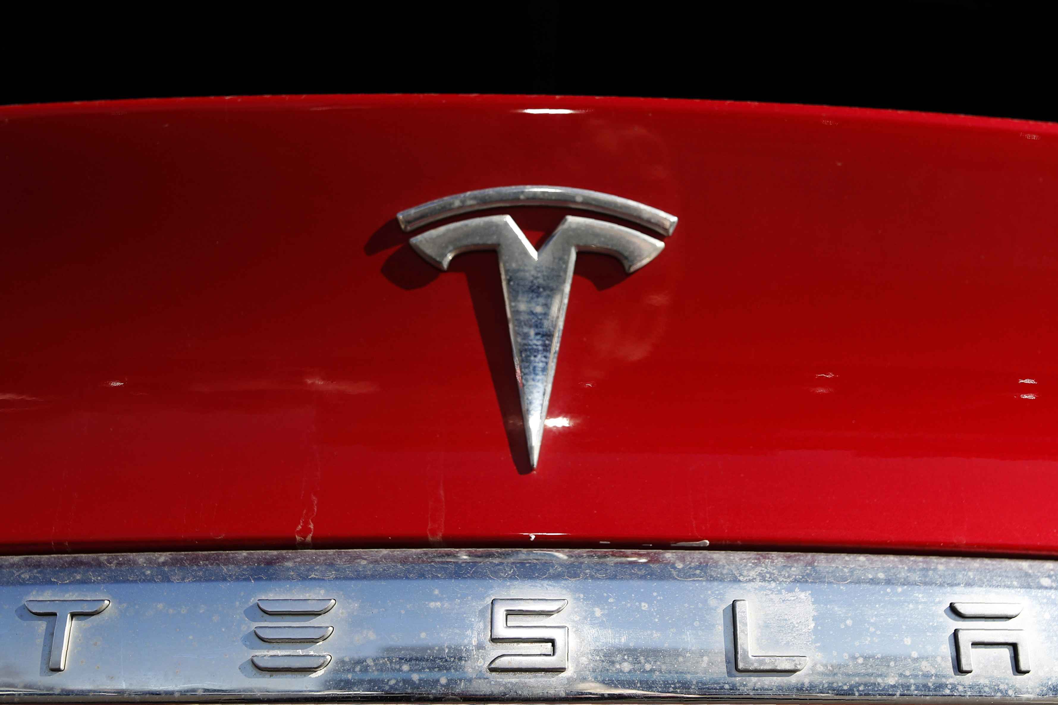 FILE - The Tesla company logo sits on an unsold 2020 Model X at a Tesla dealership in Littleton, Colo., Feb. 2, 2020. The National Highway Traffic Safety Administration said Friday, April 7, 2023, that it will probe the March 15 crash in Halifax County, North Carolina, that injured a 17-year-old student. The State Highway Patrol said the driver of the 2022 Tesla Model Y, a 51-year-old male, failed to stop for the bus, which was displaying all of its activated warning devices. (AP Photo/David Zalubowski, File)