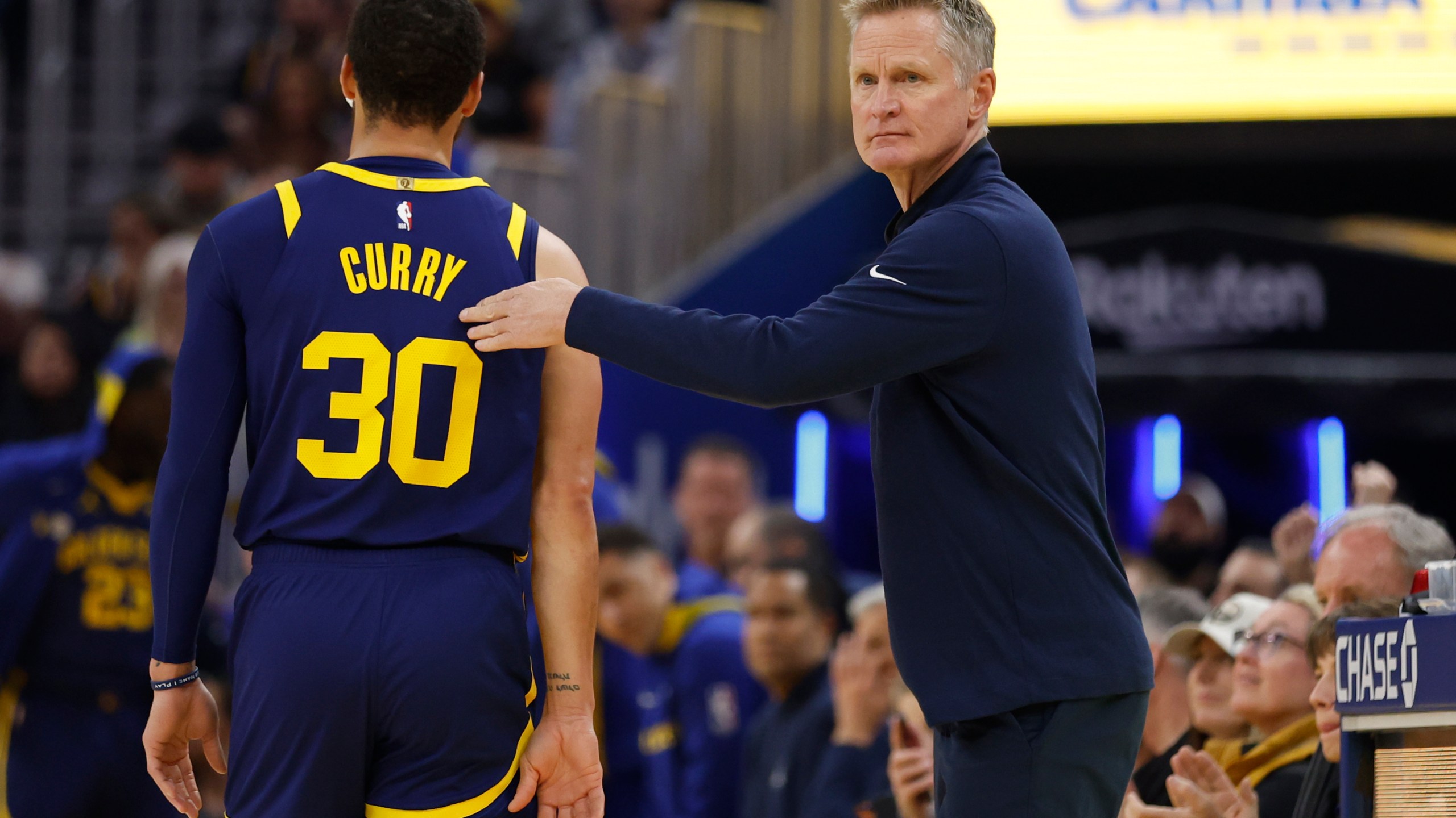 Golden State Warriors head coach Steve Kerr, right, greets Stephen Curry, left, who heads to the bench during the first half of an NBA basketball game against the San Antonio Spurs in San Francisco, Friday, March 31, 2023. (AP Photo/Jed Jacobsohn)