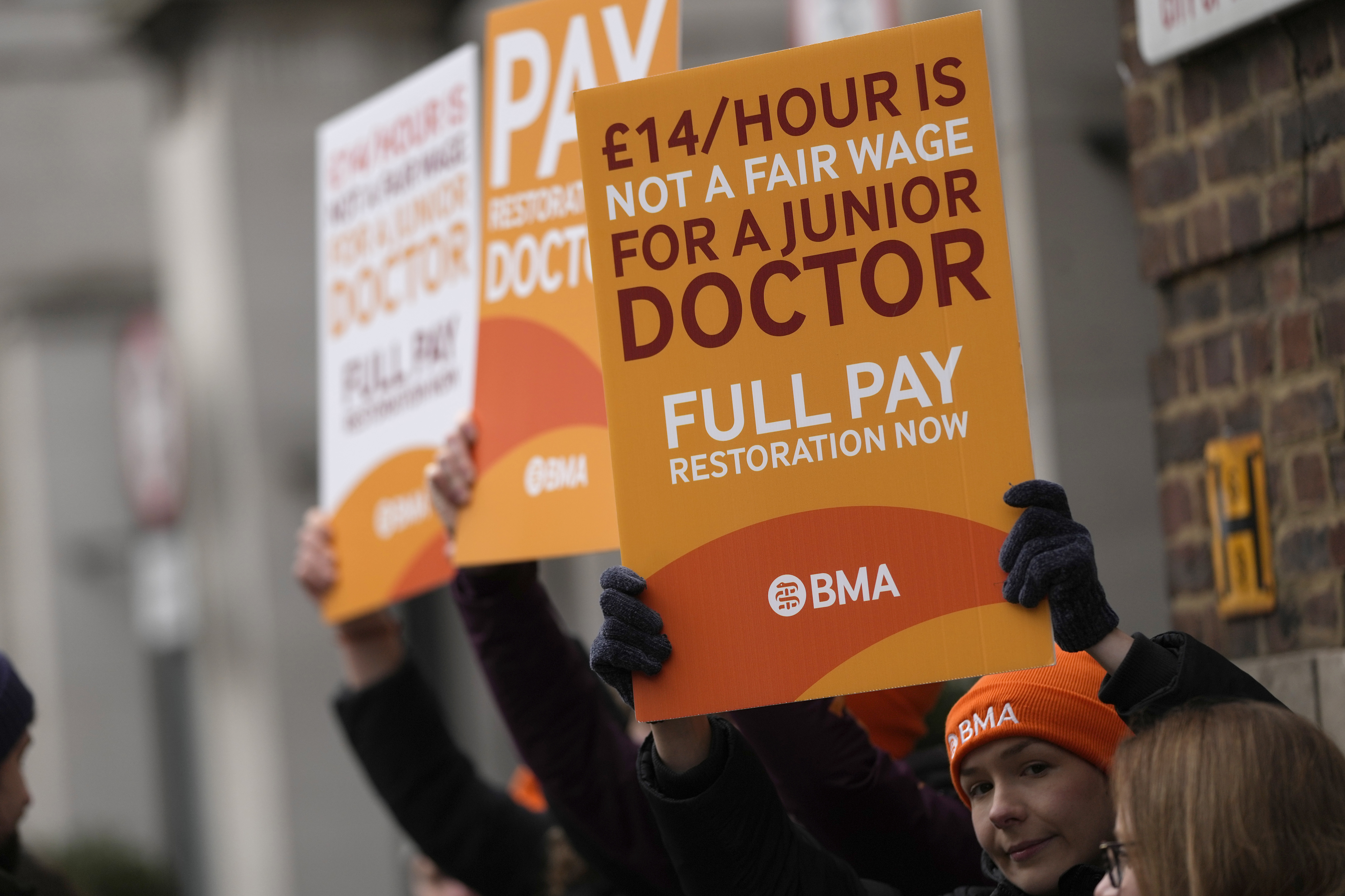 FILE - Junior doctors hold placards on a picket line outside St Mary's Hospital in London, Tuesday, March 14, 2023. A four-day strike planned by tens of thousands of doctors in England next week could lead to the postponement of a quarter-million medical appointments, a National Health Service official said Saturday, April 8, 2023. (AP Photo/Alastair Grant, File)