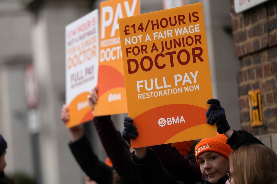 FILE - Junior doctors hold placards on a picket line outside St Mary's Hospital in London, Tuesday, March 14, 2023. A four-day strike planned by tens of thousands of doctors in England next week could lead to the postponement of a quarter-million medical appointments, a National Health Service official said Saturday, April 8, 2023. (AP Photo/Alastair Grant, File)