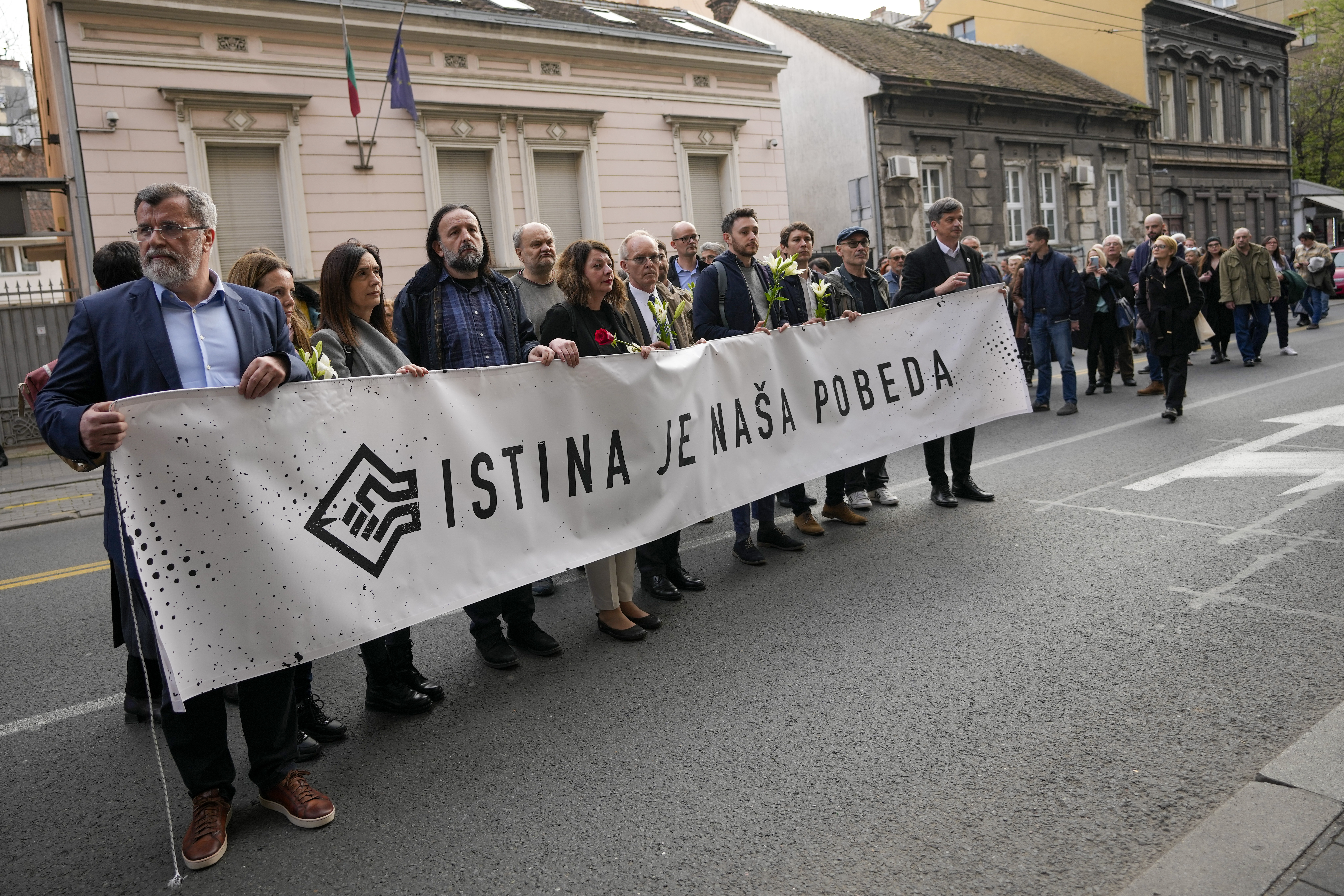 Serbian journalists hold banner reading: "Truth is our victory" as they march to mark the 24th anniversary of the killing of a prominent editor and newspaper publisher Slavko Curuvija who was fiercely critical of the government, in Belgrade, Serbia, Tuesday, April 11, 2023. Independent media organizations, both local and international, warn that critical journalists still face threats because of their work. (AP Photo/Darko Vojinovic)