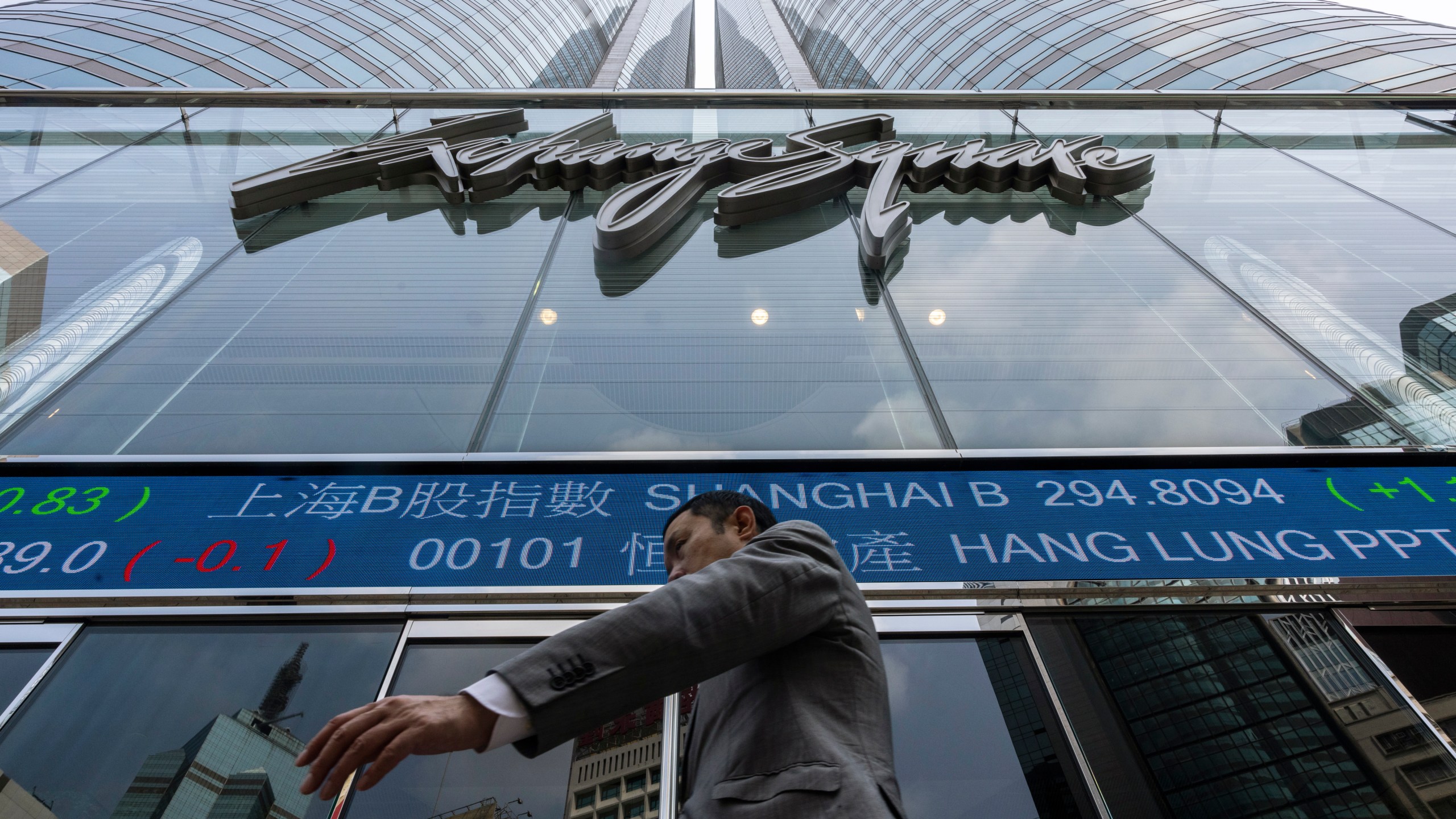 A pedestrian passes by the Hong Kong Stock Exchange electronic screen in Hong Kong, Wednesday, April 12, 2023. Asian shares were mostly higher Wednesday, as markets watched for key inflation data likely to influence the Federal Reserve's stance on interest rates. (AP Photo/Louise Delmotte)