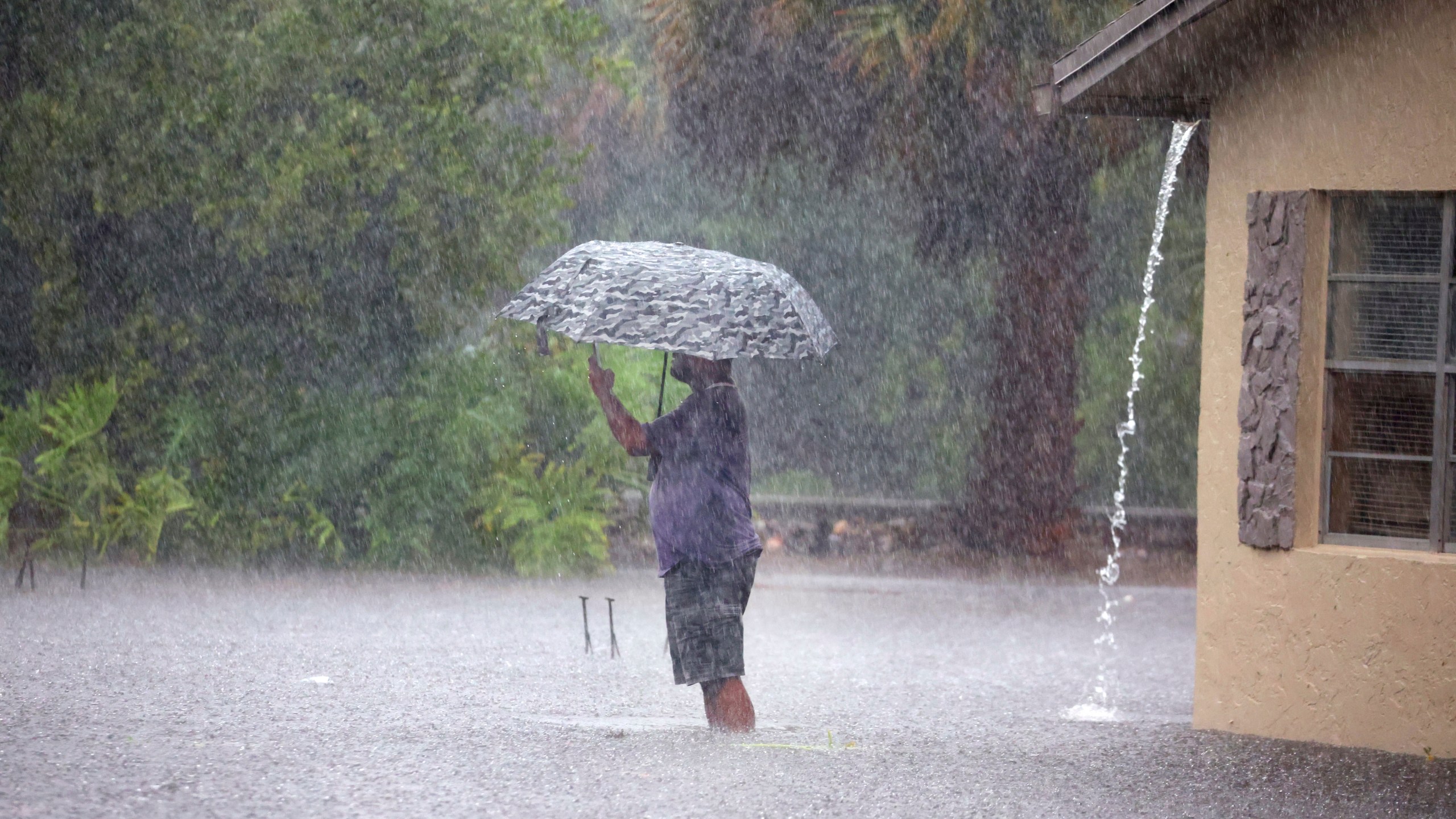 A man stops to take pictures of his flooded neighborhood along SW 3rd Street and SW 4th Ave in Dania Beach, Fla., on Wednesday, April 12, 2023. (Carline Jean/South Florida Sun-Sentinel via AP)