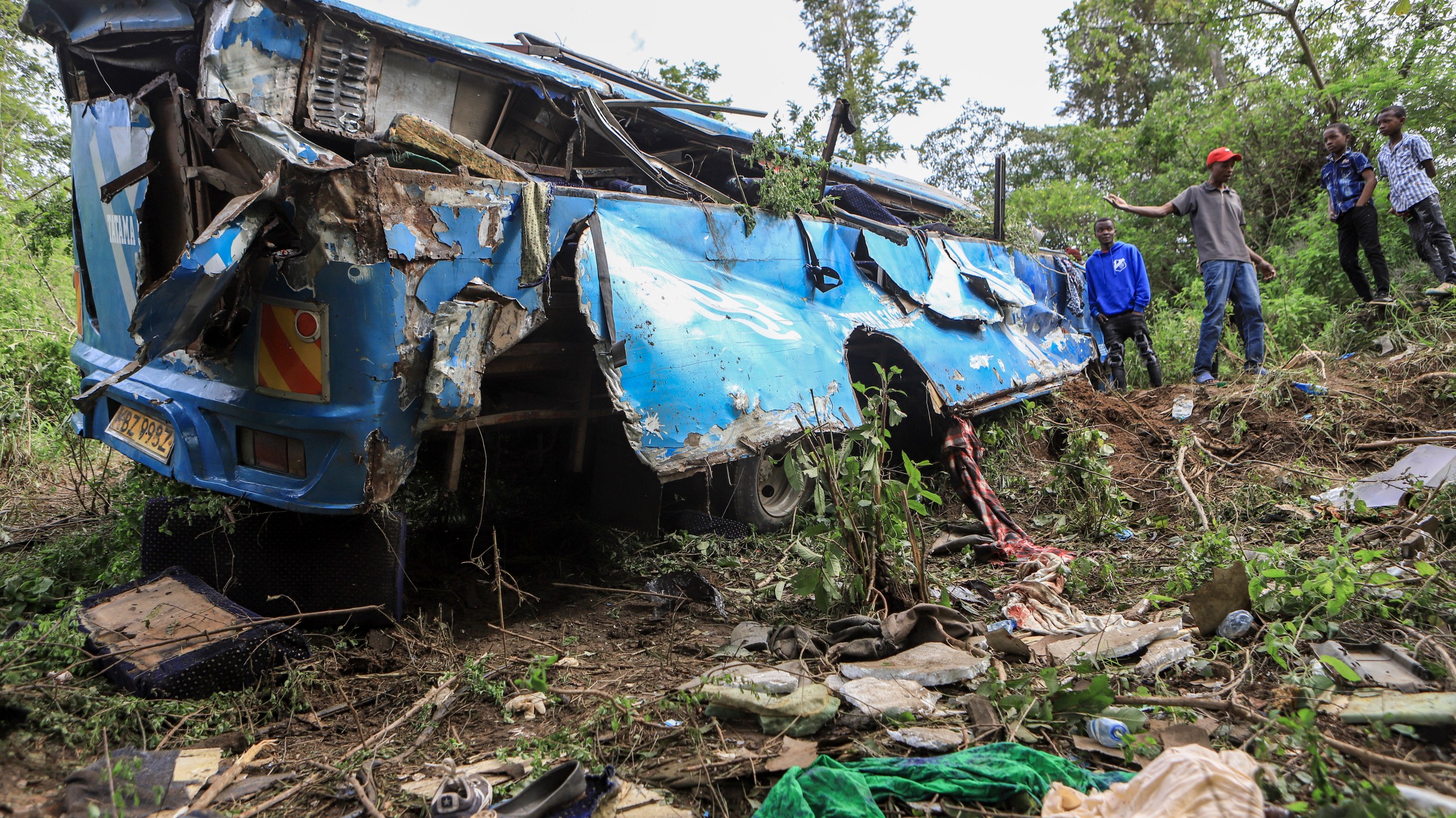 People observe the wreckage at the scene of a bus crash involving dozens of mourners who were returning from a funeral, near Mwatate, in southern Kenya, Sunday, April 16, 2023. At least 10 people died when the bus they were traveling in left the road and rolled several times in southern Kenya, police said Sunday. (AP Photo)