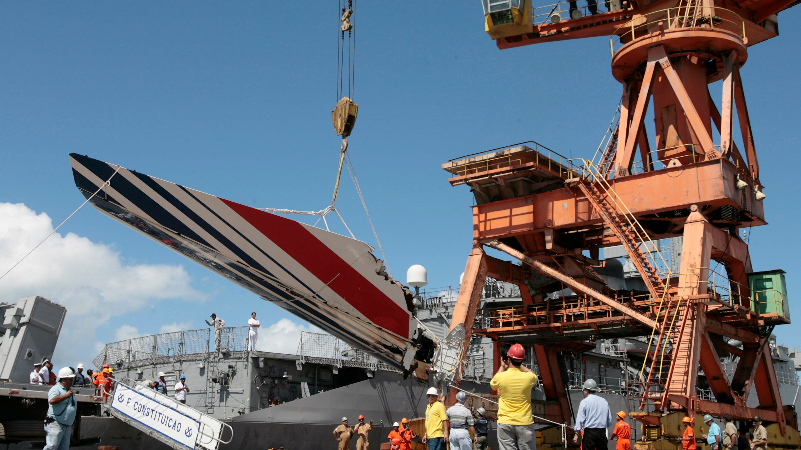 FILE - Workers unloading debris, belonging to crashed Air France flight AF447, from the Brazilian Navy's Constitution Frigate in the port of Recife, northeast of Brazil, Sunday, June 14, 2009. A French court is ruling Monday April 17, 2023 on whether Airbus and Air France are guilty of manslaughter over the 2009 crash of Flight 447 en route from Rio to Paris, which killed 228 people and led to lasting changes in aircraft safety measures. (AP Photo/Eraldo Peres, File)