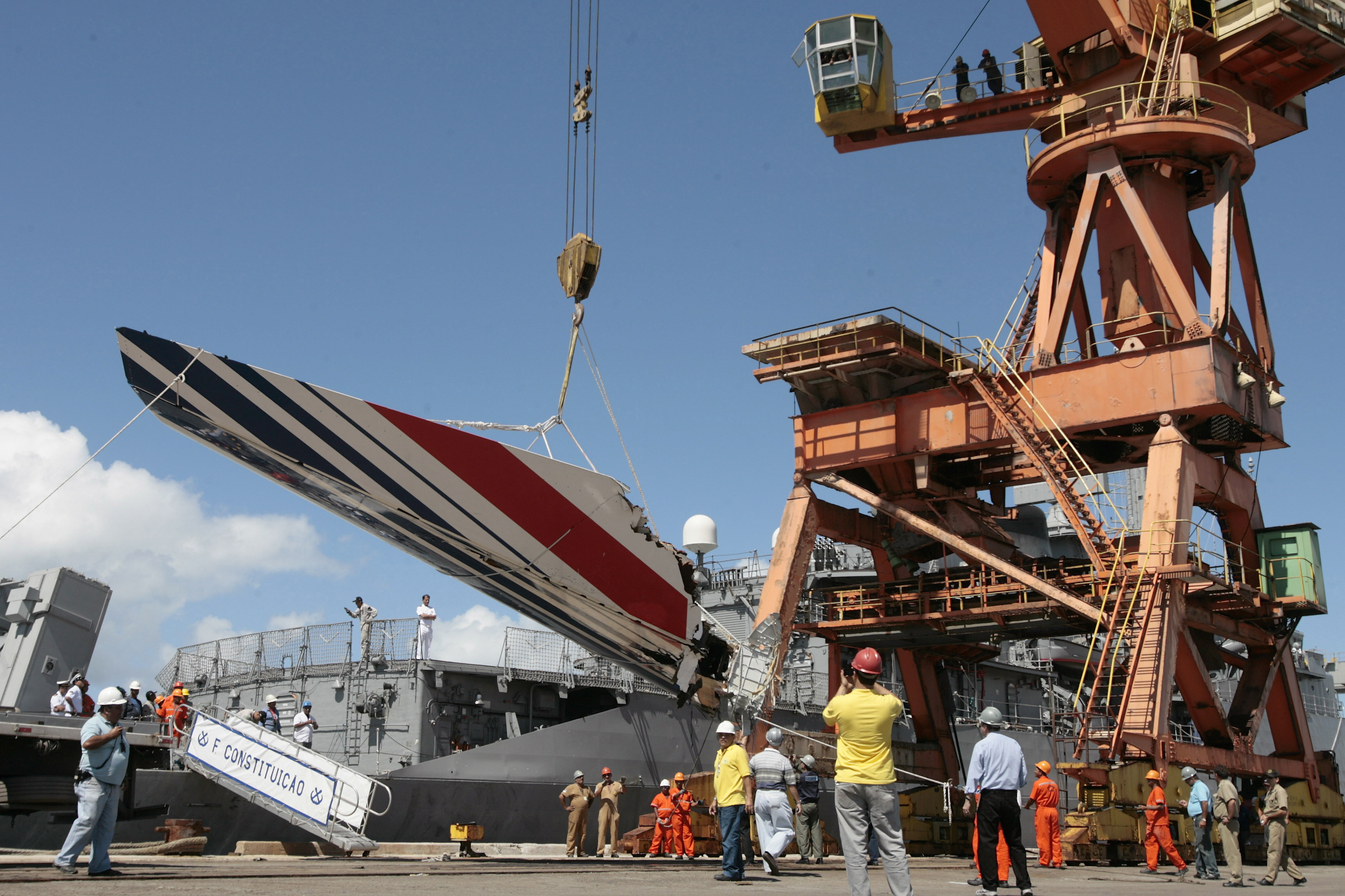 FILE - Workers unloading debris, belonging to crashed Air France flight AF447, from the Brazilian Navy's Constitution Frigate in the port of Recife, northeast of Brazil, Sunday, June 14, 2009. A French court is ruling Monday April 17, 2023 on whether Airbus and Air France are guilty of manslaughter over the 2009 crash of Flight 447 en route from Rio to Paris, which killed 228 people and led to lasting changes in aircraft safety measures. (AP Photo/Eraldo Peres, File)