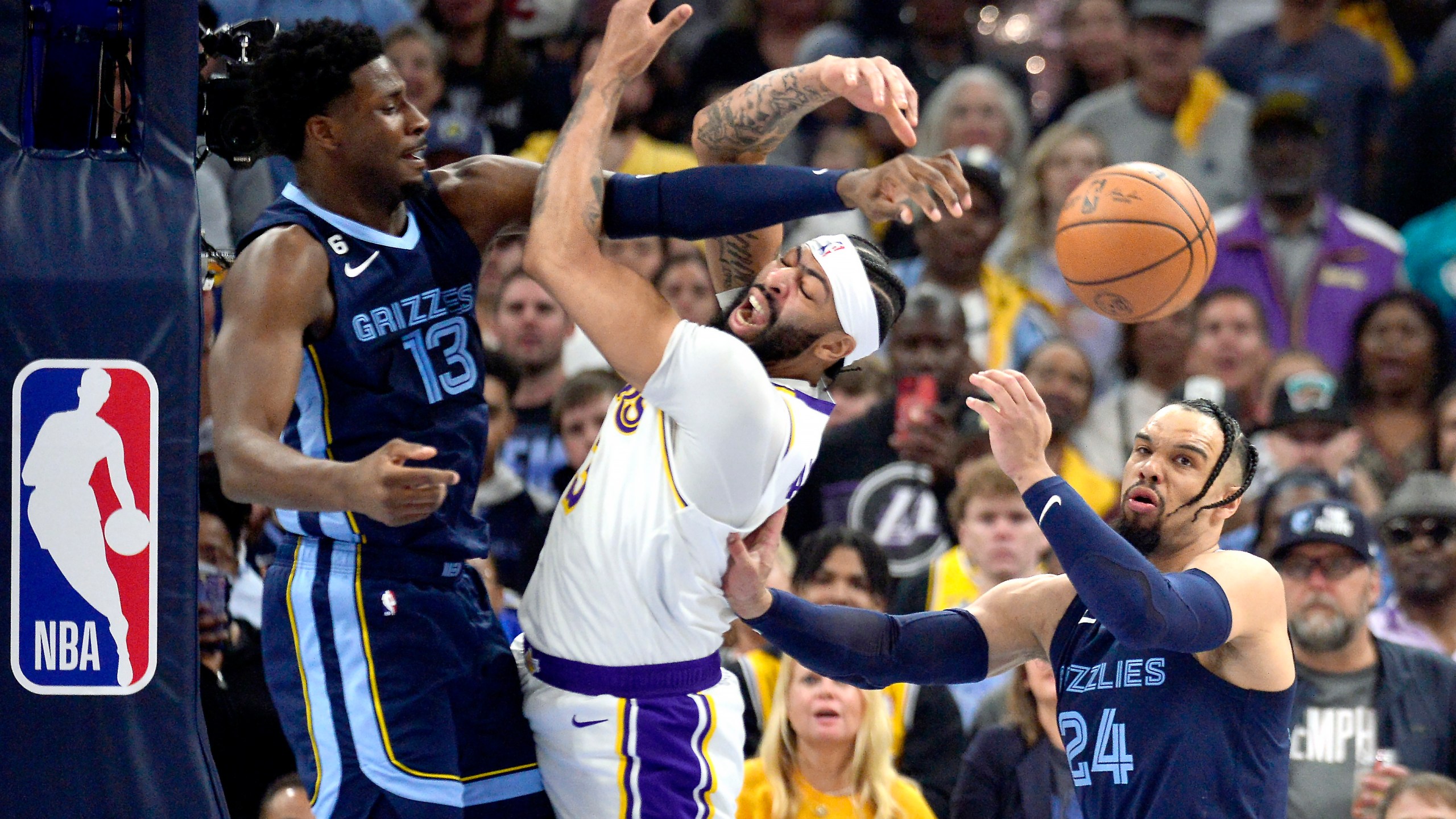 Los Angeles Lakers forward Anthony Davis (3), center, loses control of the ball between Memphis Grizzlies forwards Jaren Jackson Jr. (13) and Dillon Brooks (24) during Game 1 of a first-round NBA basketball playoff series Sunday, April 16, 2023, in Memphis, Tenn. (AP Photo/Brandon Dill)