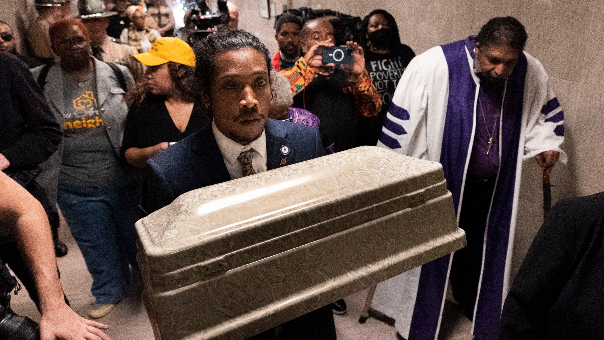 Rep. Justin Jones, D-Nashville, carries a casket through the halls of the state Capitol with Rev. William J. Barber, right, Monday, April 17, 2023, in Nashville, Tenn. (AP Photo/George Walker IV)