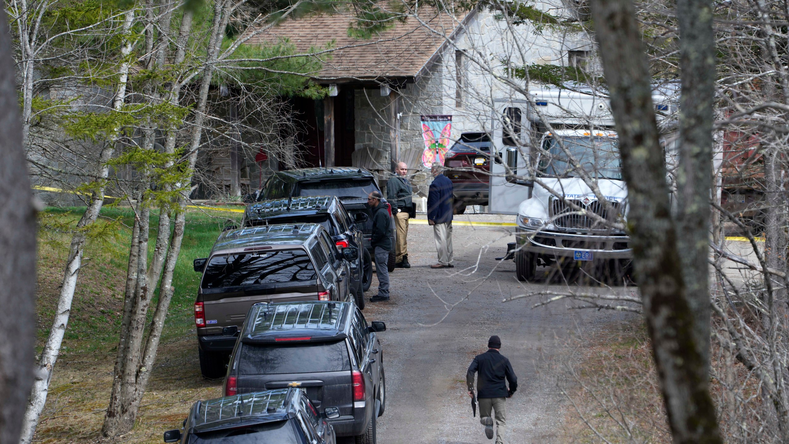 Investigators work at the scene of a deadly shooting, Tuesday, April 18, 2023, in Bowdoin, Maine. State police in Maine say gunfire that erupted on busy highway is linked to a second crime scene where four people were found dead in a home about 25 miles away. (AP Photo/Robert F. Bukaty)