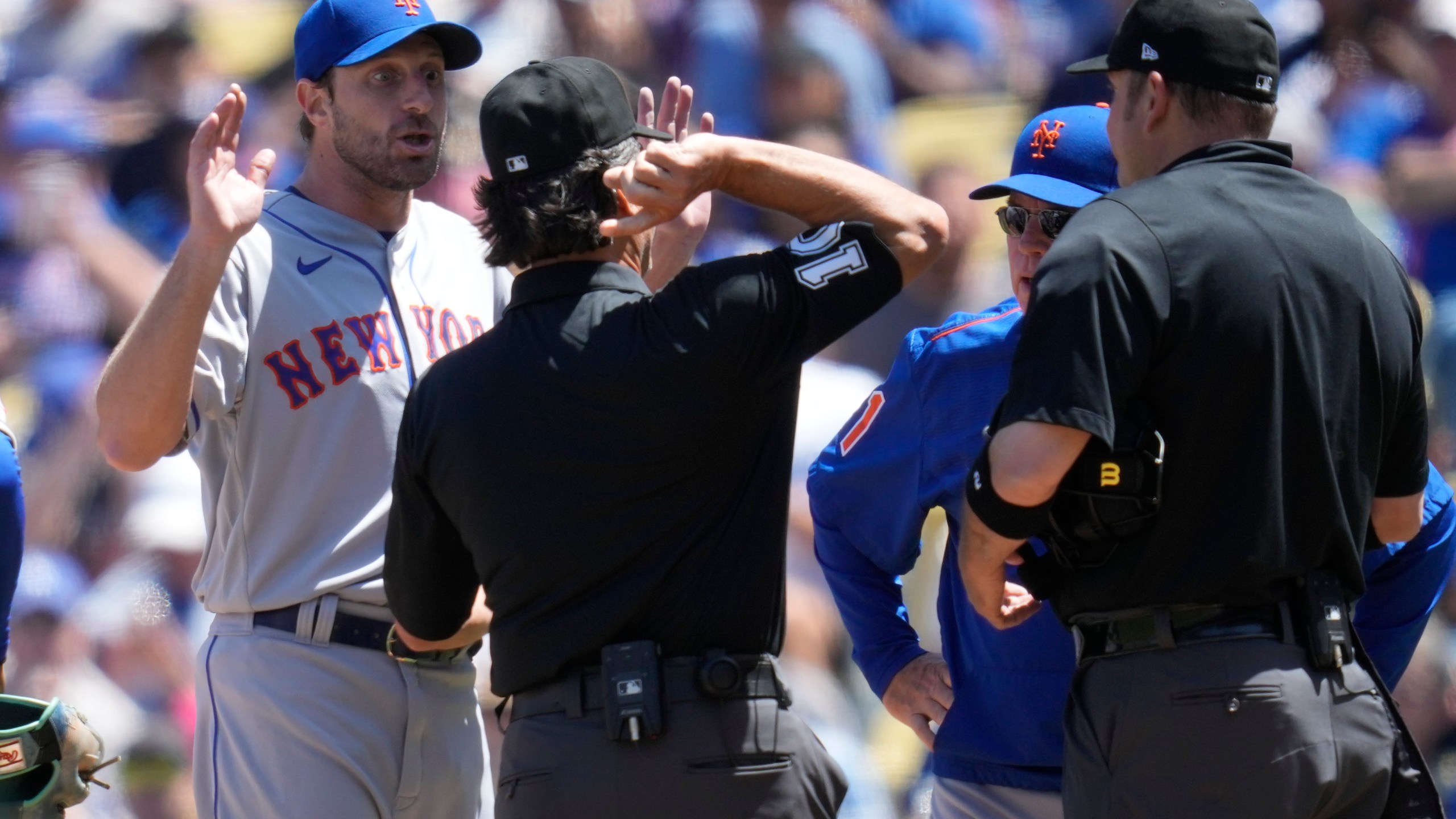 New York Mets starting pitcher Max Scherzer, left, is ejected from the game as he and manager Buck Showalter dispute a call from umpire Phil Cuzzi, center, and umpire Dan Bellino, right, after they found a problem with Scherzer's glove during the fourth inning of a baseball game in Los Angeles, Wednesday, April 19, 2023. (AP Photo/Ashley Landis)