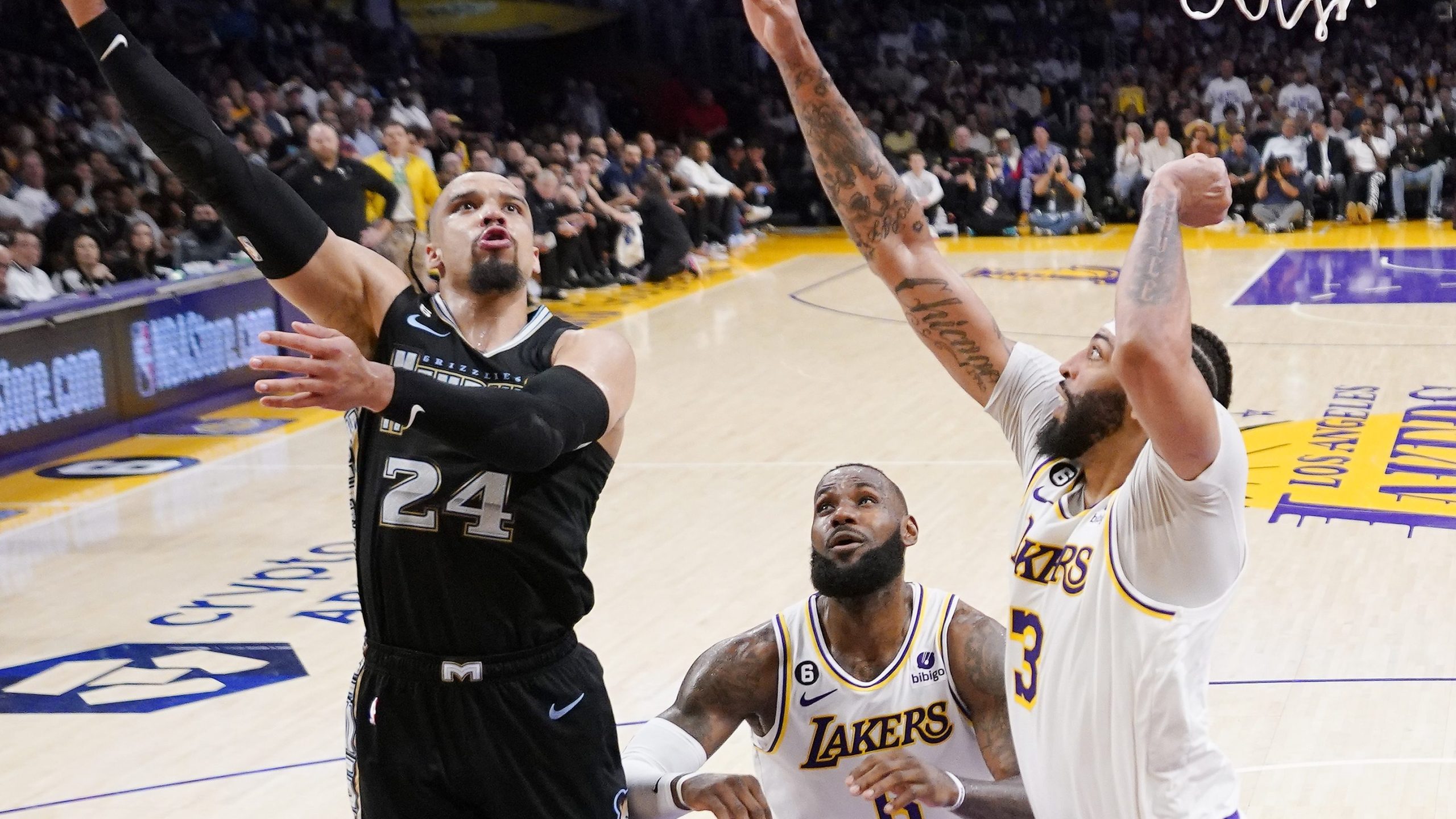 Memphis Grizzlies forward Dillon Brooks, left, shoots as Los Angeles Lakers forward LeBron James, center, and forward Anthony Davis defend during the first half in Game 3 of a first-round NBA basketball playoff series Saturday, April 22, 2023, in Los Angeles. (AP Photo/Mark J. Terrill)