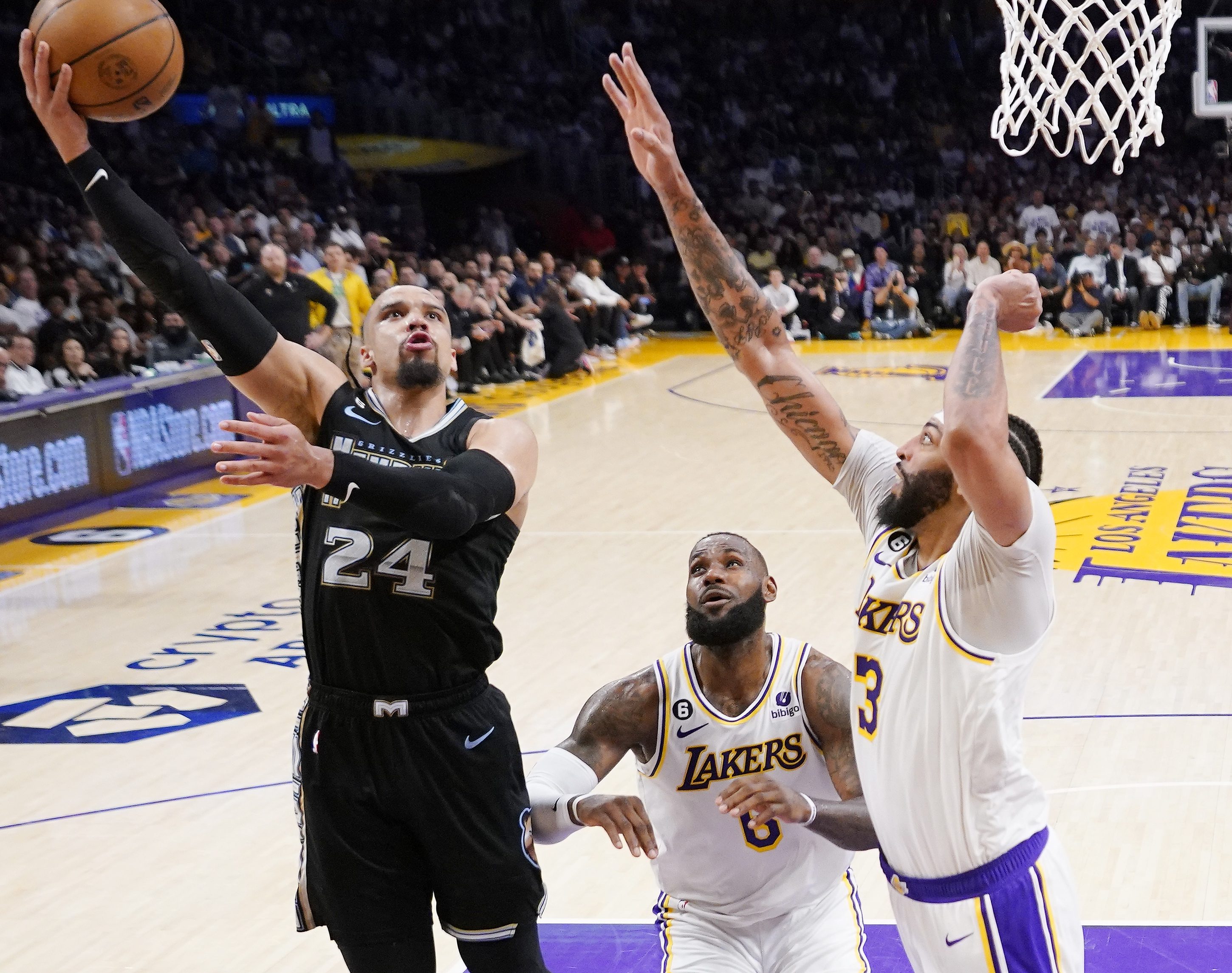 Memphis Grizzlies forward Dillon Brooks, left, shoots as Los Angeles Lakers forward LeBron James, center, and forward Anthony Davis defend during the first half in Game 3 of a first-round NBA basketball playoff series Saturday, April 22, 2023, in Los Angeles. (AP Photo/Mark J. Terrill)