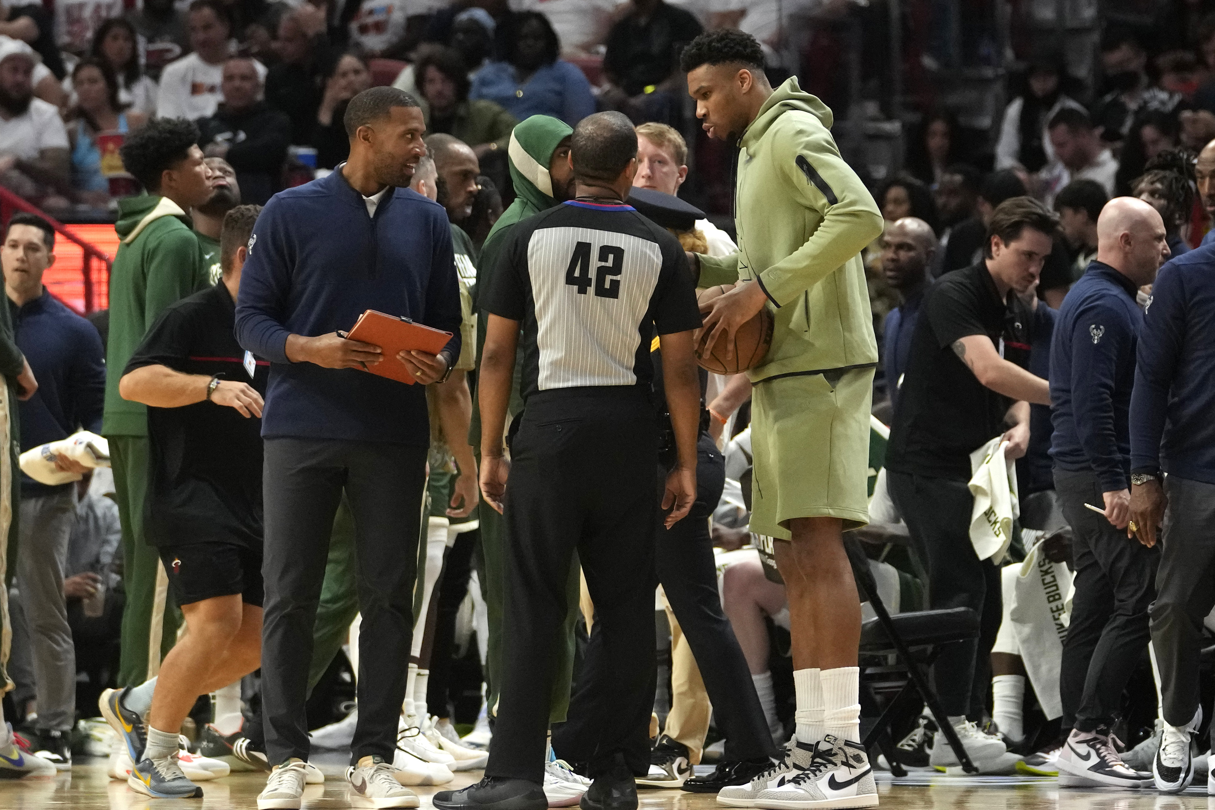 Milwaukee Bucks forward Giannis Antetokounmpo, right, talks with official Eric Lewis (42) during the first half of Game 3 in a first-round NBA basketball playoff series against the Miami Heat, Saturday, April 22, 2023, in Miami. (AP Photo/Lynne Sladky)