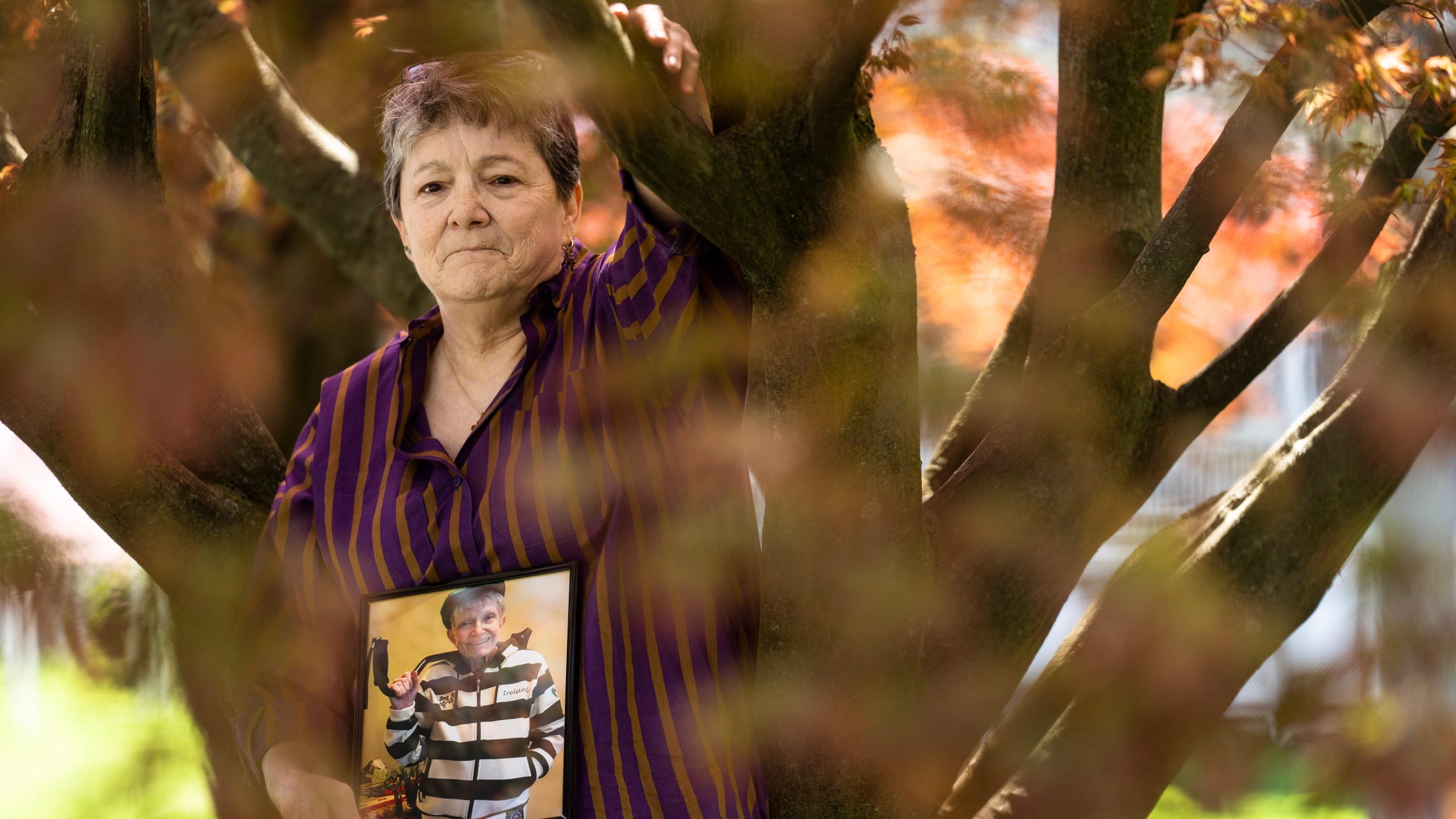 Georgene White stands for a portrait with a photo of her mother, Teri Sheridan, in Belvidere, N.J., Thursday, April 20, 2023. At age 93, struggling with the effects of a stroke, heart failure and recurrent cancer, Sheridan was ready to end her life using New Jersey's law that allows medically assisted suicide - but she was bedbound, too sick to travel. So on Nov. 17, 2022, surrounded by three of her children, Sheridan drank a lethal dose of drugs prescribed by a doctor she had never met in person, only online. She died within minutes. (AP Photo/Matt Rourke)