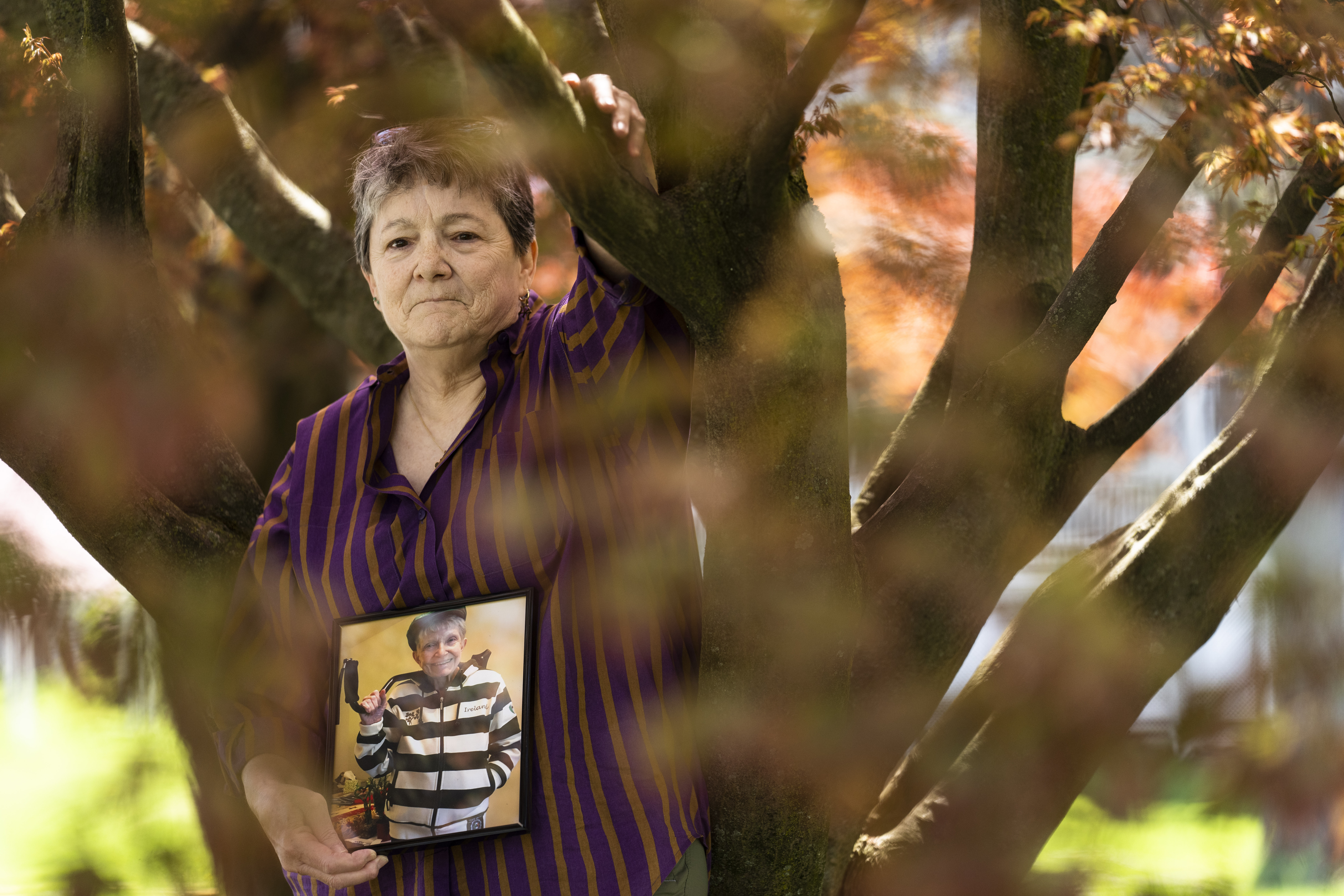 Georgene White stands for a portrait with a photo of her mother, Teri Sheridan, in Belvidere, N.J., Thursday, April 20, 2023. At age 93, struggling with the effects of a stroke, heart failure and recurrent cancer, Sheridan was ready to end her life using New Jersey's law that allows medically assisted suicide - but she was bedbound, too sick to travel. So on Nov. 17, 2022, surrounded by three of her children, Sheridan drank a lethal dose of drugs prescribed by a doctor she had never met in person, only online. She died within minutes. (AP Photo/Matt Rourke)