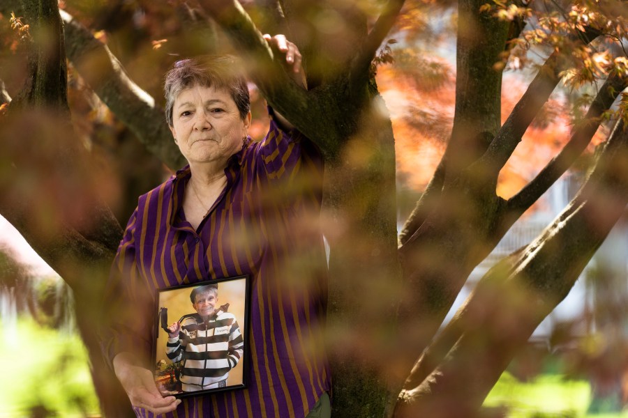 Georgene White stands for a portrait with a photo of her mother, Teri Sheridan, in Belvidere, N.J., Thursday, April 20, 2023. At age 93, struggling with the effects of a stroke, heart failure and recurrent cancer, Sheridan was ready to end her life using New Jersey's law that allows medically assisted suicide - but she was bedbound, too sick to travel. So on Nov. 17, 2022, surrounded by three of her children, Sheridan drank a lethal dose of drugs prescribed by a doctor she had never met in person, only online. She died within minutes. (AP Photo/Matt Rourke)