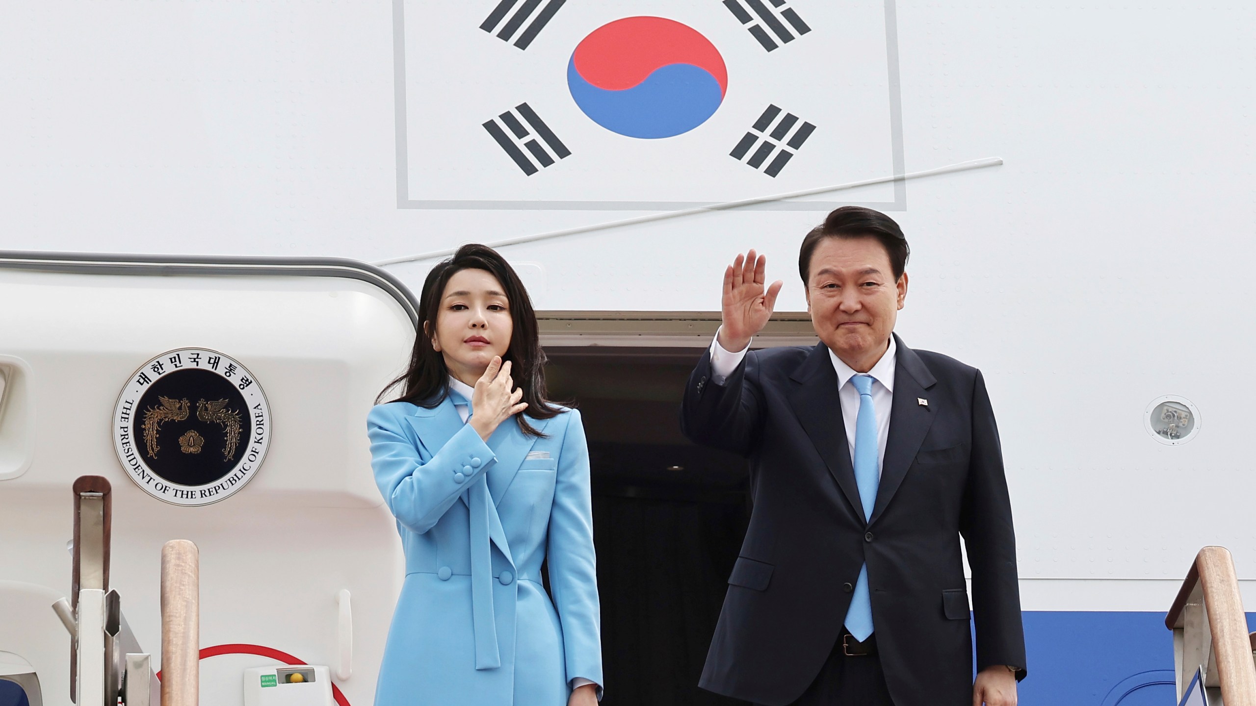 South Korean President Yoon Suk Yeol, right, waves as his wife Kim Keon Hee stands before departing for the United States at the Seoul military airport in Seongnam, South Korea, Monday, April 24, 2023. Yoon on Monday departed for Washington D.C. to meet with U.S. President Joe Biden. (Lim Hun-jung/Yonhap via AP)