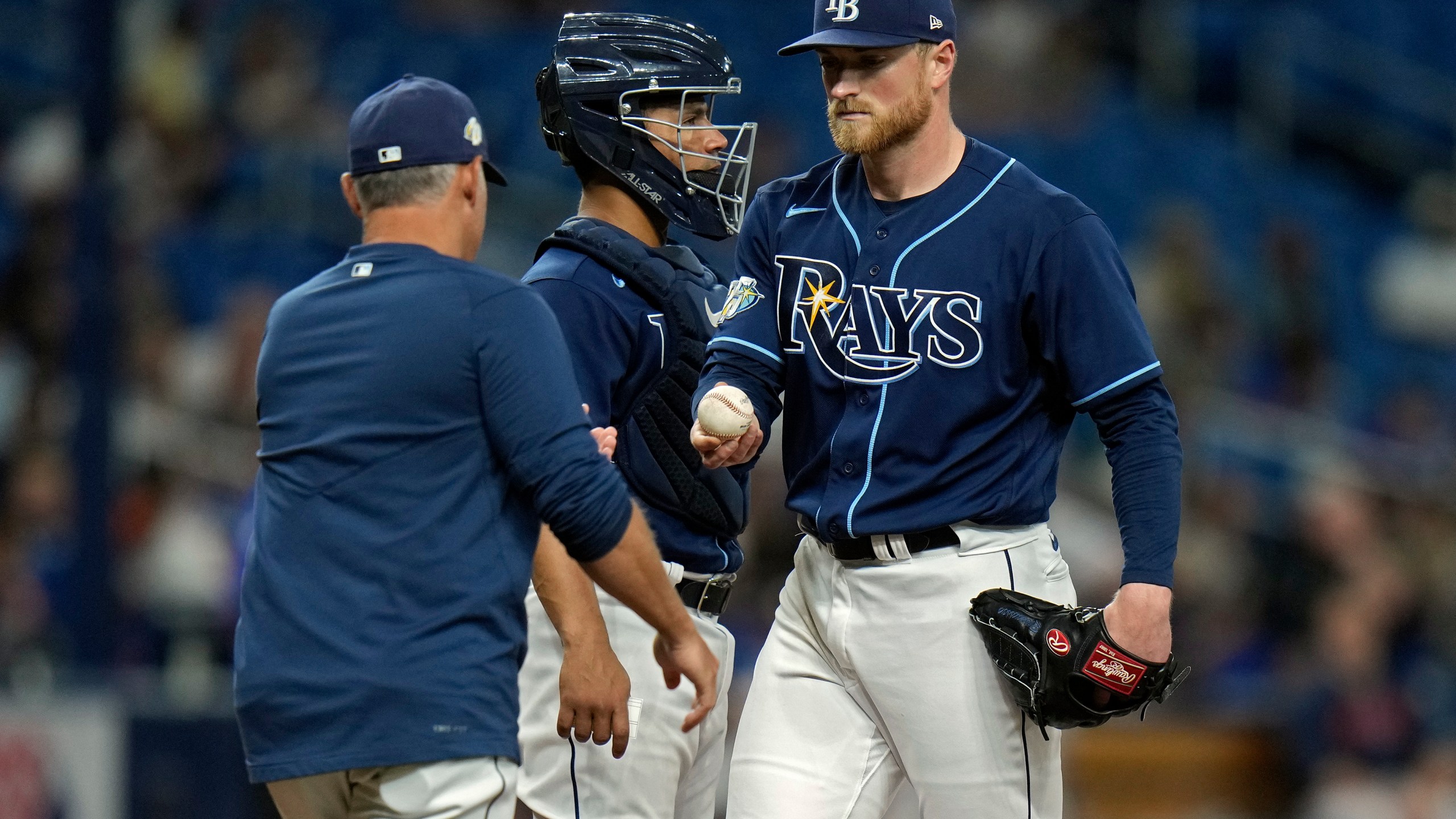 Tampa Bay Rays starting pitcher Drew Rasmussen, right, hands the ball to manager Kevin Cash, left, as he is taken out of the game against the Houston Astros during the fifth inning of a baseball game Tuesday, April 25, 2023, in St. Petersburg, Fla. Looking in is Rays' catcher Francisco Mejia. (AP Photo/Chris O'Meara)