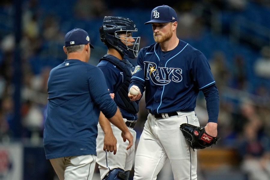 Tampa Bay Rays starting pitcher Drew Rasmussen, right, hands the ball to manager Kevin Cash, left, as he is taken out of the game against the Houston Astros during the fifth inning of a baseball game Tuesday, April 25, 2023, in St. Petersburg, Fla. Looking in is Rays' catcher Francisco Mejia. (AP Photo/Chris O'Meara)