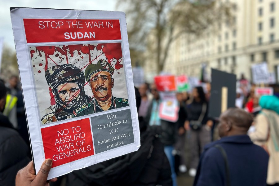 A demonstrator calling for the end of fighting in Sudan holds up a sign Sunday, April 23, 2023, outside Britain's Ministry of Defense in London. Sudanese emigrants living in the United Kingdom are worried about loved ones living in a battle zone back home and doing whatever they can to help in the dire situation.(AP Photo/Brian Melley)