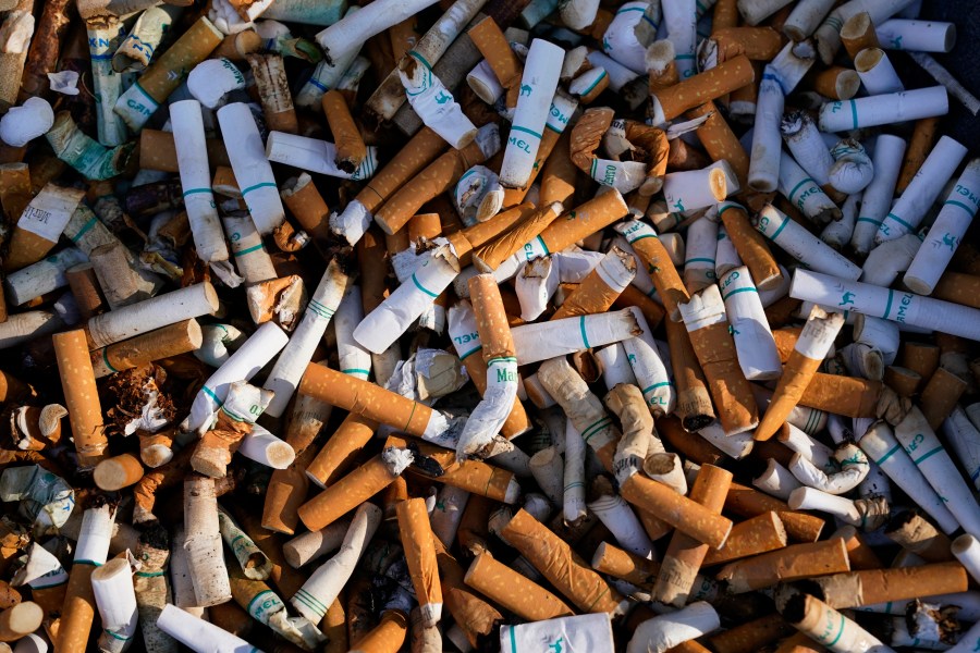 FILE - Cigarette butts fill a smoking receptacle outside a federal building in Washington, Thursday, April 15, 2021. According to government survey data released Thursday, April 27, 2023, U.S. adults are smoking less. Cigarette smoking dropped to another new all-time low in 2022, with 1 in 9 adults saying they were current smokers. Meanwhile, e-cigarette use rose, to about 1 in 17 adults. (AP Photo/J. Scott Applewhite, File)