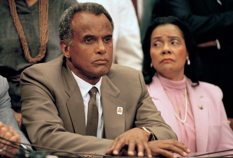 FILE - Entertainer and activist Harry Belafonte, and Coretta Scott King, widow of slain civil rights leader Dr. Martin Luther King, Jr., listen to a speaker during an anti-apartheid demonstration on Capitol Hill in Washington on Aug. 12, 1985. Belafonte died Tuesday of congestive heart failure at his New York home. He was 96. (AP Photo/Lana Harris, File)