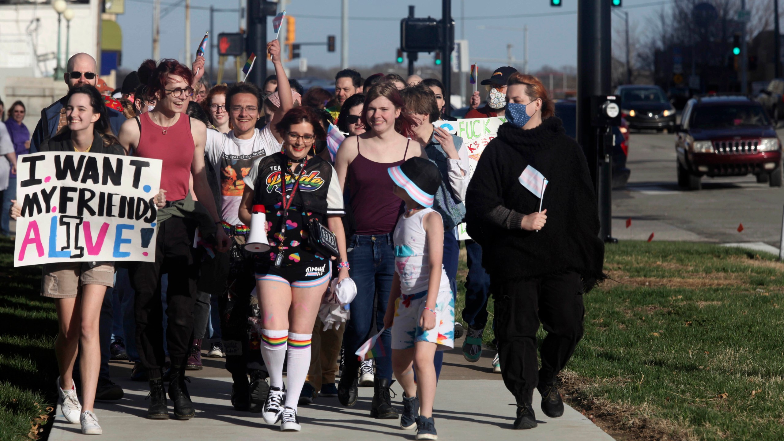 More than 100 people, many of them transgender youth, march around the Kansas Statehouse on the annual Transgender Day of Visibility, Friday, March 31, 2023, in Topeka, Kan. While the event was a celebration of transgender identity, it also was a protest against proposals before the Kansas Legislature to roll back transgender rights. (AP Photo/John Hanna)