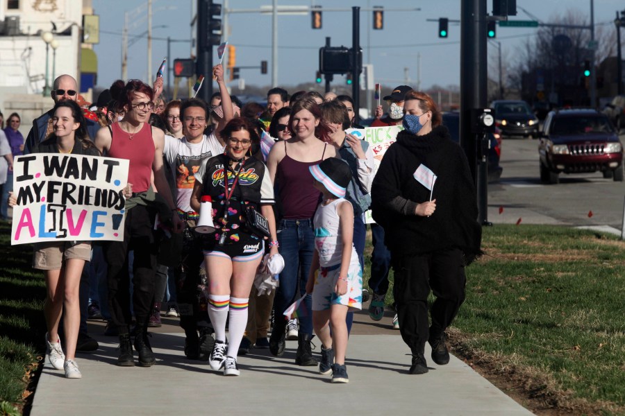 More than 100 people, many of them transgender youth, march around the Kansas Statehouse on the annual Transgender Day of Visibility, Friday, March 31, 2023, in Topeka, Kan. While the event was a celebration of transgender identity, it also was a protest against proposals before the Kansas Legislature to roll back transgender rights. (AP Photo/John Hanna)