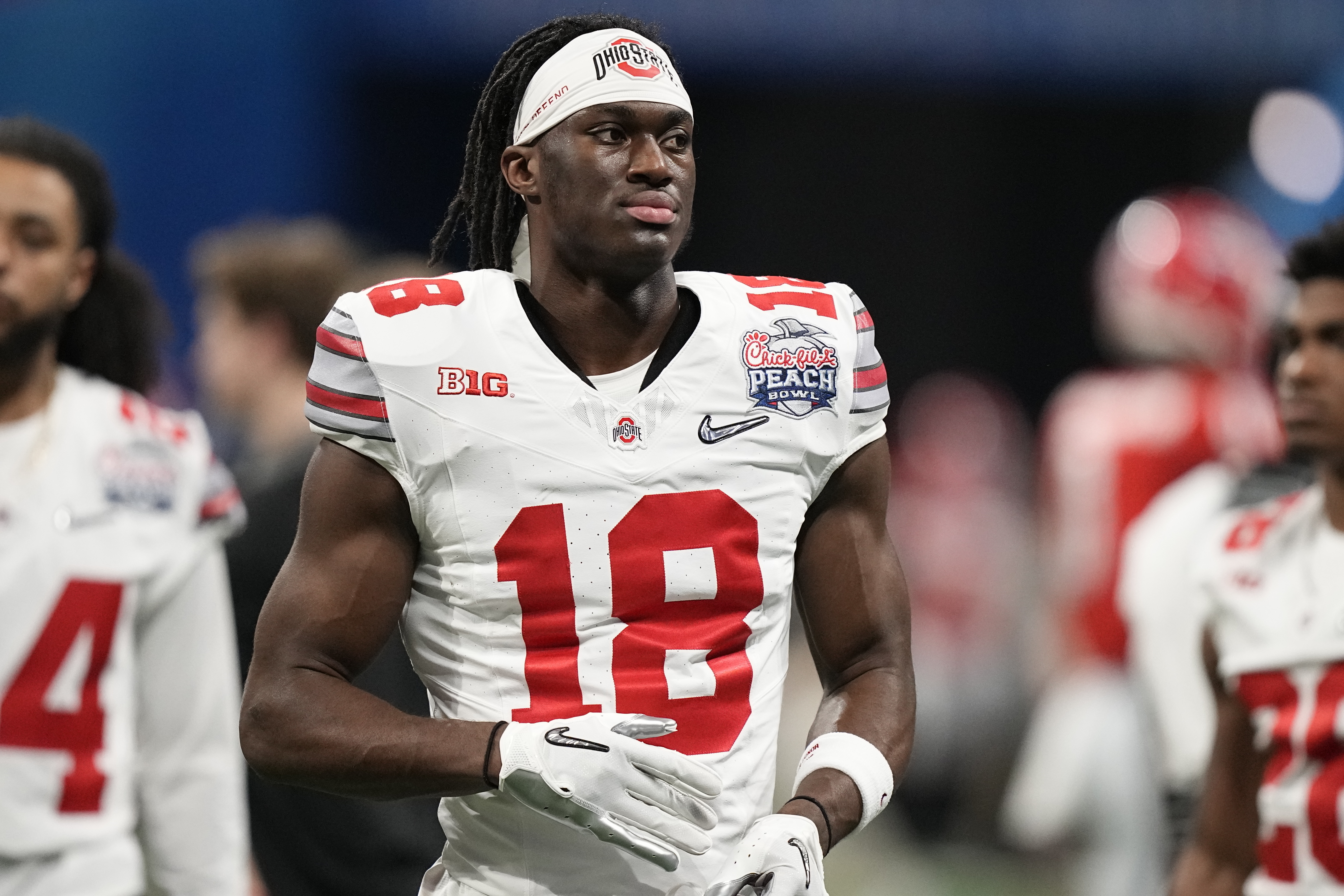 FILE - Ohio State wide receiver Marvin Harrison Jr. (18) warms up before the Peach Bowl NCAA college football semifinal playoff game between Georgia and Ohio State, Saturday, Dec. 31, 2022, in Atlanta. The 2024 NFL draft class could be tank-worthy. With a full season of college football still to be played, two future franchise quarterbacks are already being penciled into the top of draft boards. (AP Photo/Brynn Anderson, File)