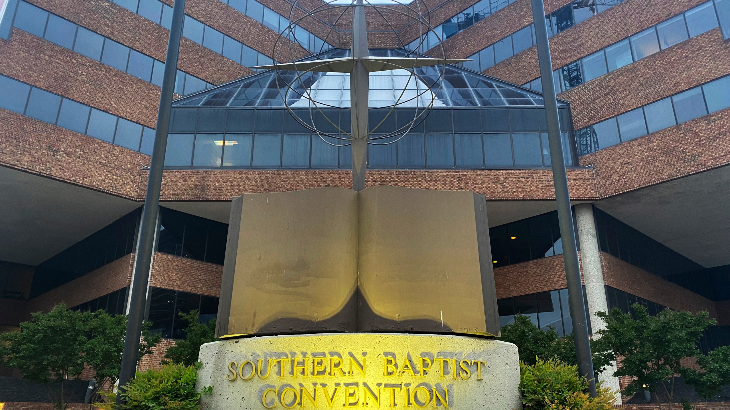 FILE - A cross and Bible sculpture stand outside the Southern Baptist Convention headquarters in Nashville, Tenn., May 24, 2022. A powerful Southern Baptist committee was looking to appoint a new leader Monday, May 1, 2023, who could navigate controversies over its handling of sexual-abuse reforms and the ousting of churches with women serving as pastors. Instead, the Executive Committee found itself tangled in yet another dispute, voting down a recommendation to make its own former chairman its president in what had become a racially fraught decision. (AP Photo/Holly Meyer, File)