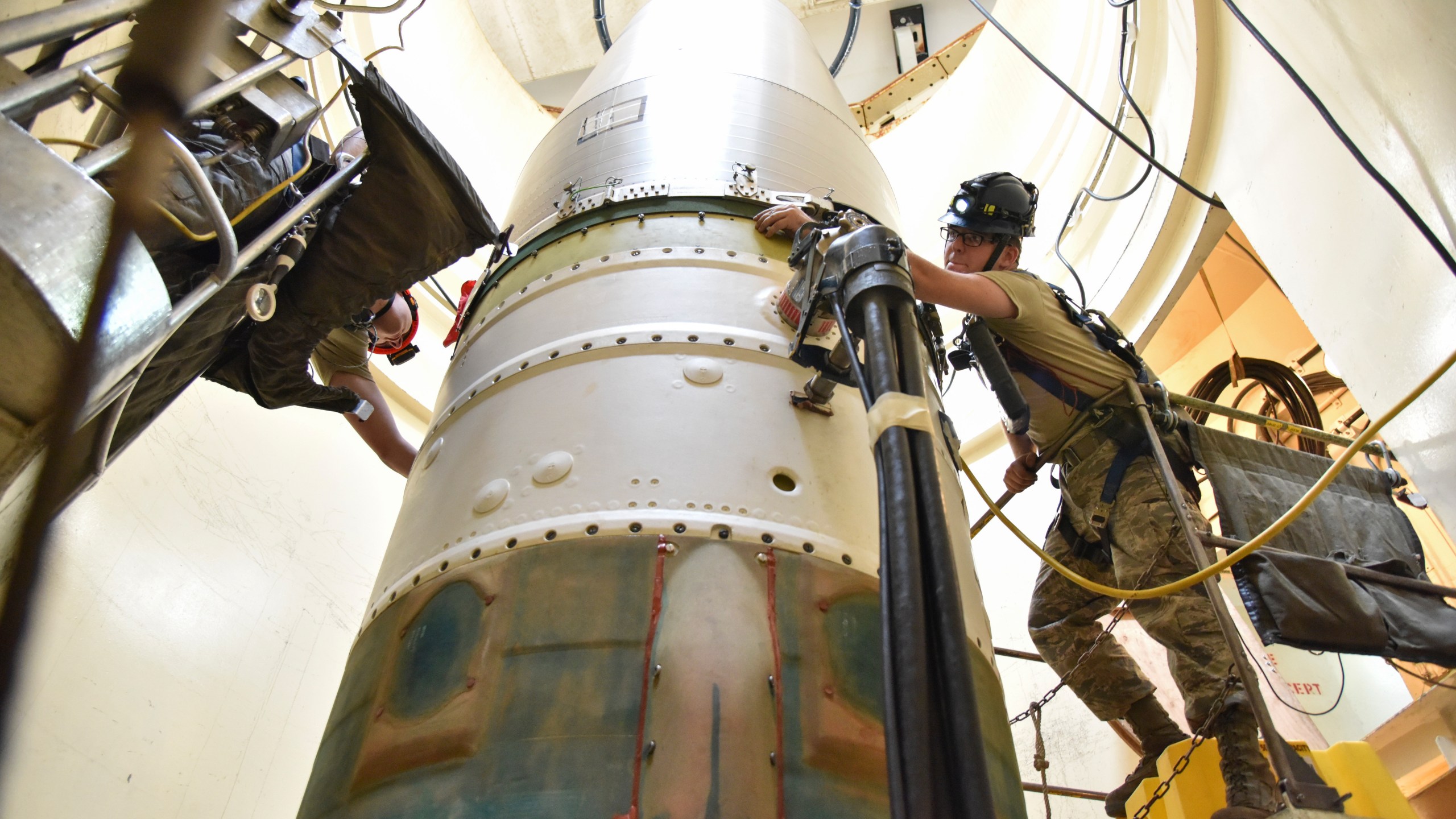 FILE - In this image provided by the U.S. Air Force, Airman 1st Class Jackson Ligon, left, and Senior Airman Jonathan Marinaccio, 341st Missile Maintenance Squadron technicians, connect a re-entry system to a spacer on an intercontinental ballistic missile during a Simulated Electronic Launch-Minuteman test Sept. 22, 2020, at a launch facility near Malmstrom Air Force Base in Great Falls, Mont. The Air Force says a review of a Montana nuclear missile base where an unusual number of troops have reported being diagnosed with non-Hodgkin's lymphoma has found no immediate risk factors. The same was true at two other bases that could launch ground-based warheads, the service said in a report obtained by the Associated Press. (Senior Airman Daniel Brosam/U.S. Air Force via AP, File)