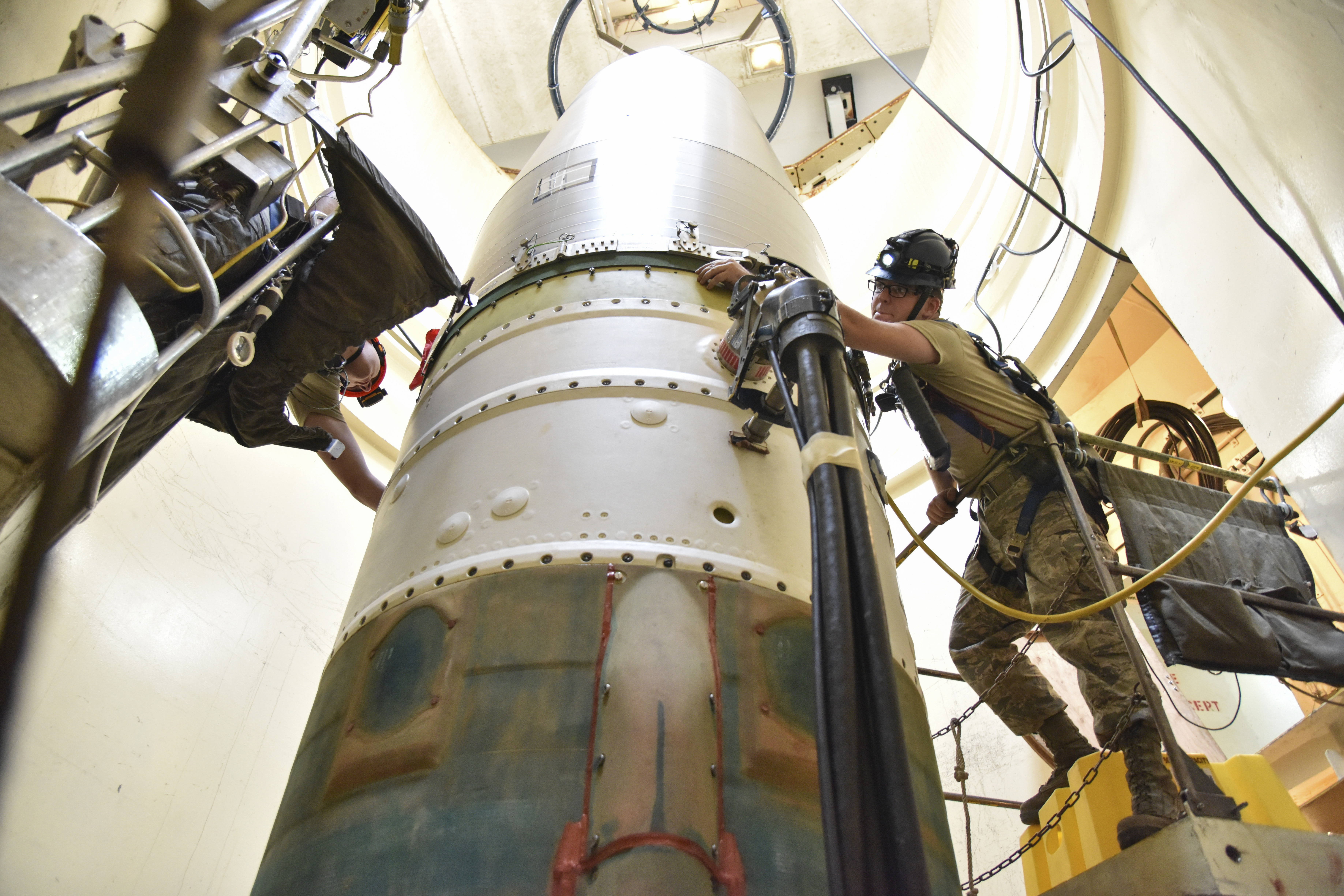 FILE - In this image provided by the U.S. Air Force, Airman 1st Class Jackson Ligon, left, and Senior Airman Jonathan Marinaccio, 341st Missile Maintenance Squadron technicians, connect a re-entry system to a spacer on an intercontinental ballistic missile during a Simulated Electronic Launch-Minuteman test Sept. 22, 2020, at a launch facility near Malmstrom Air Force Base in Great Falls, Mont. The Air Force says a review of a Montana nuclear missile base where an unusual number of troops have reported being diagnosed with non-Hodgkin's lymphoma has found no immediate risk factors. The same was true at two other bases that could launch ground-based warheads, the service said in a report obtained by the Associated Press. (Senior Airman Daniel Brosam/U.S. Air Force via AP, File)