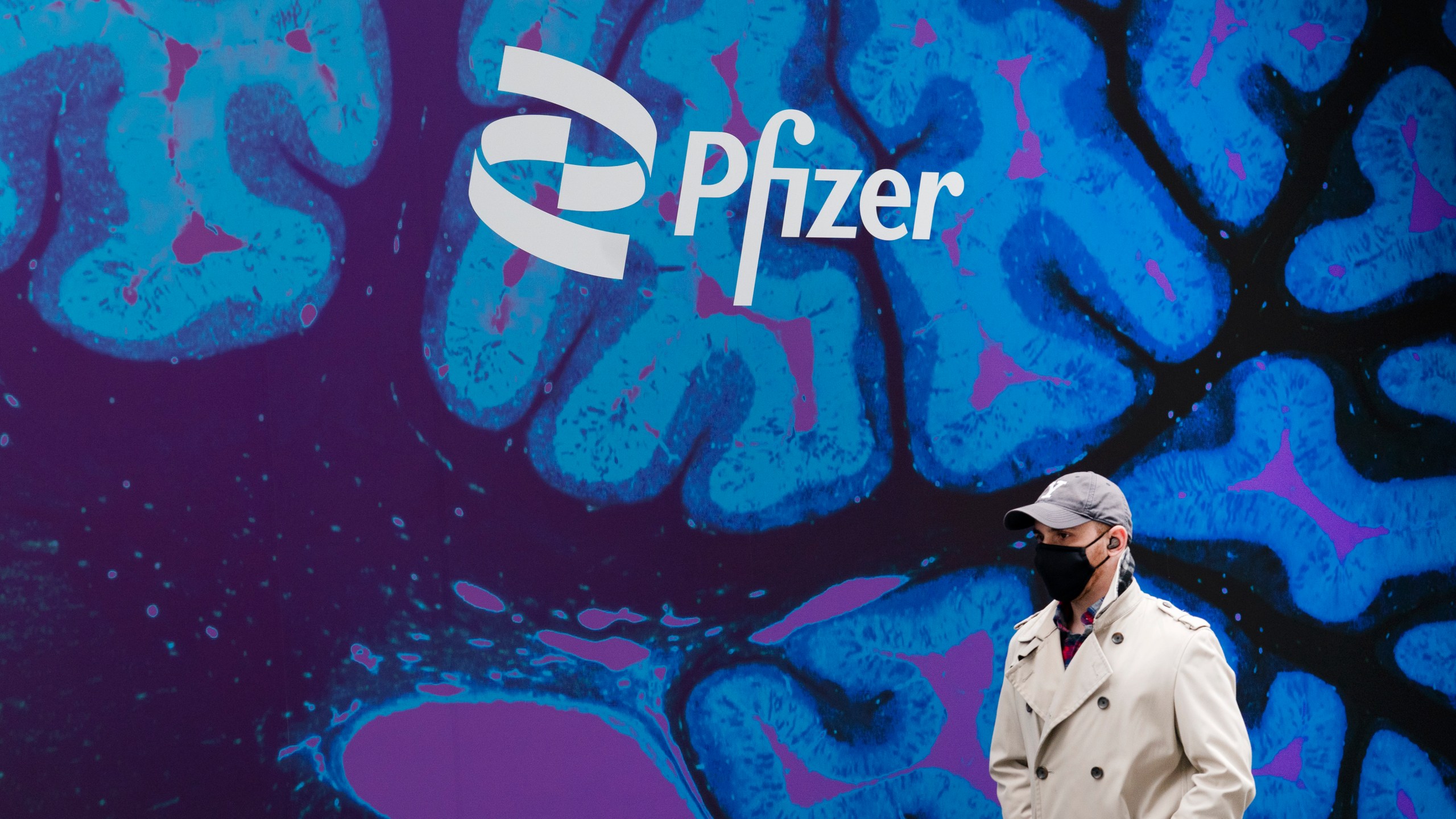 FILE - A man walks by Pfizer headquarters, Friday, Feb. 5, 2021 in New York. Pfizer reports their earnings on Tuesday, May 2, 2023. (AP Photo/Mark Lennihan, File)