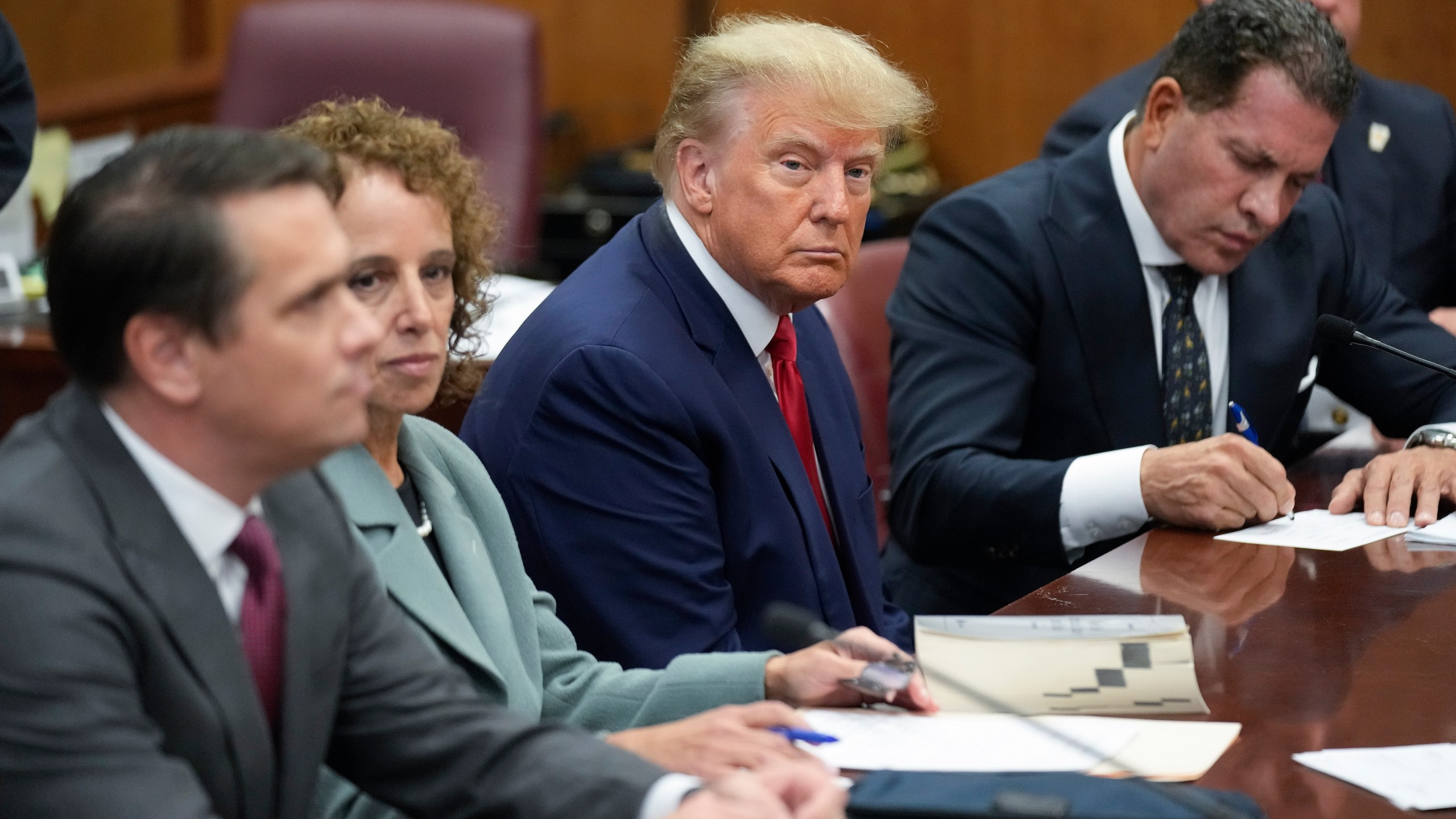 FILE - Former President Donald Trump sits at the defense table with his legal team in a Manhattan court, April 4, 2023, in New York. A judge known for his care and cautiousness in presiding over litigation in the aftermath of the 9/11 attacks was selected Friday, May 5, to decide whether Trump’s criminal case proceeds in state or federal court. (AP Photo/Seth Wenig, Pool, File)