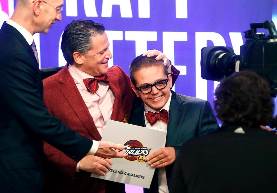 FILE - In this May 21, 2013, file photo, Cleveland Cavaliers owner Dan Gilbert congratulates his son, Nick Gilbert, after the team won the NBA basketball draft lottery in New York. Nicolas “Nick” Gilbert, who became the team's good luck charm at NBA draft lotteries, has died. He was 26. A funeral announcement posted by the Ira Kaufman Chapel said Gilbert died Saturday, May 6, 2023 “peacefully at home surrounded by family.” (AP Photo/Jason DeCrow, File)