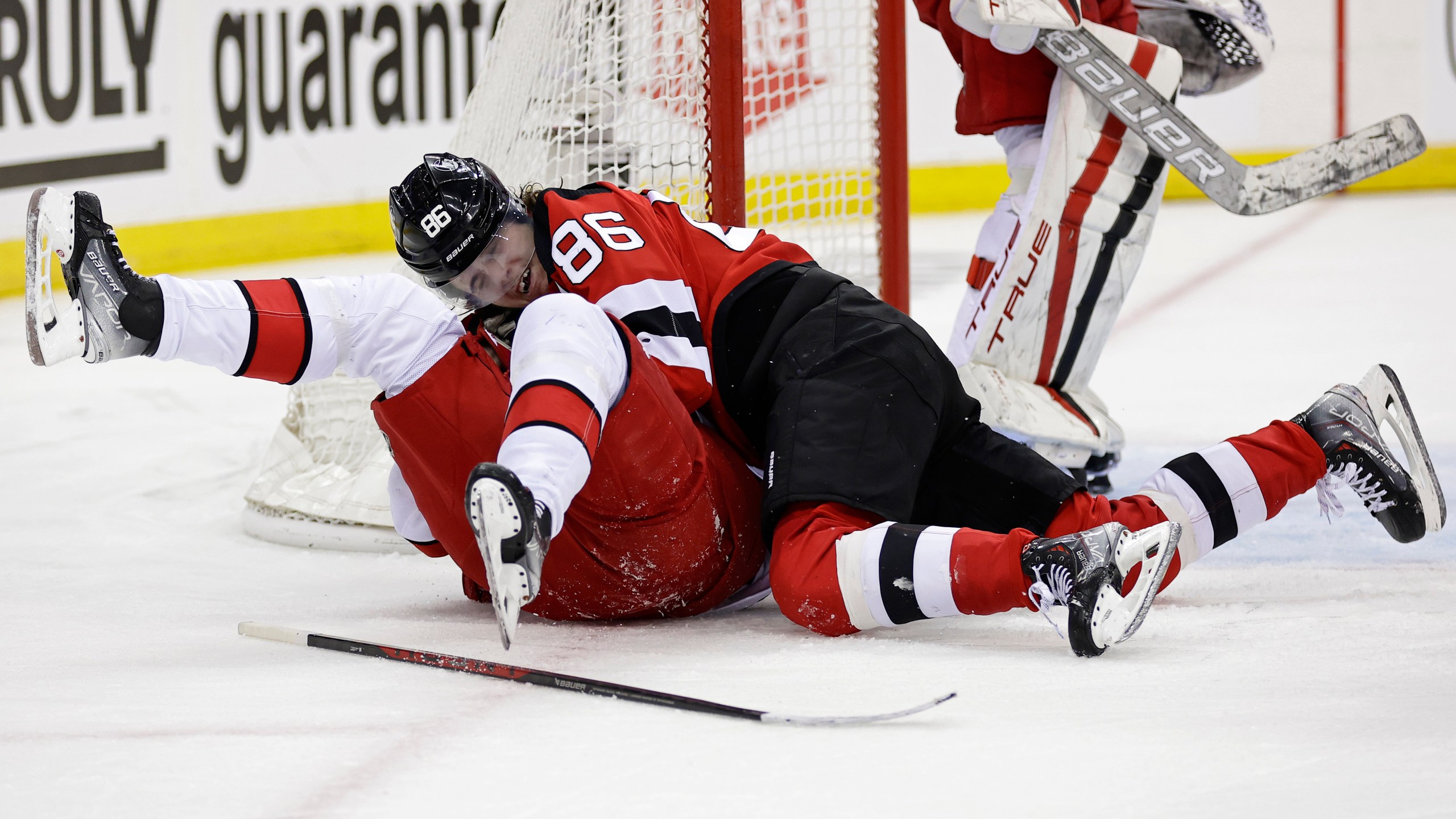 New Jersey Devils center Jack Hughes (86) fights with Carolina Hurricanes center Sebastian Aho during the second period of Game 3 of an NHL hockey Stanley Cup second-round playoff series, Sunday, May 7, 2023, in Newark, N.J. (AP Photo/Adam Hunger)