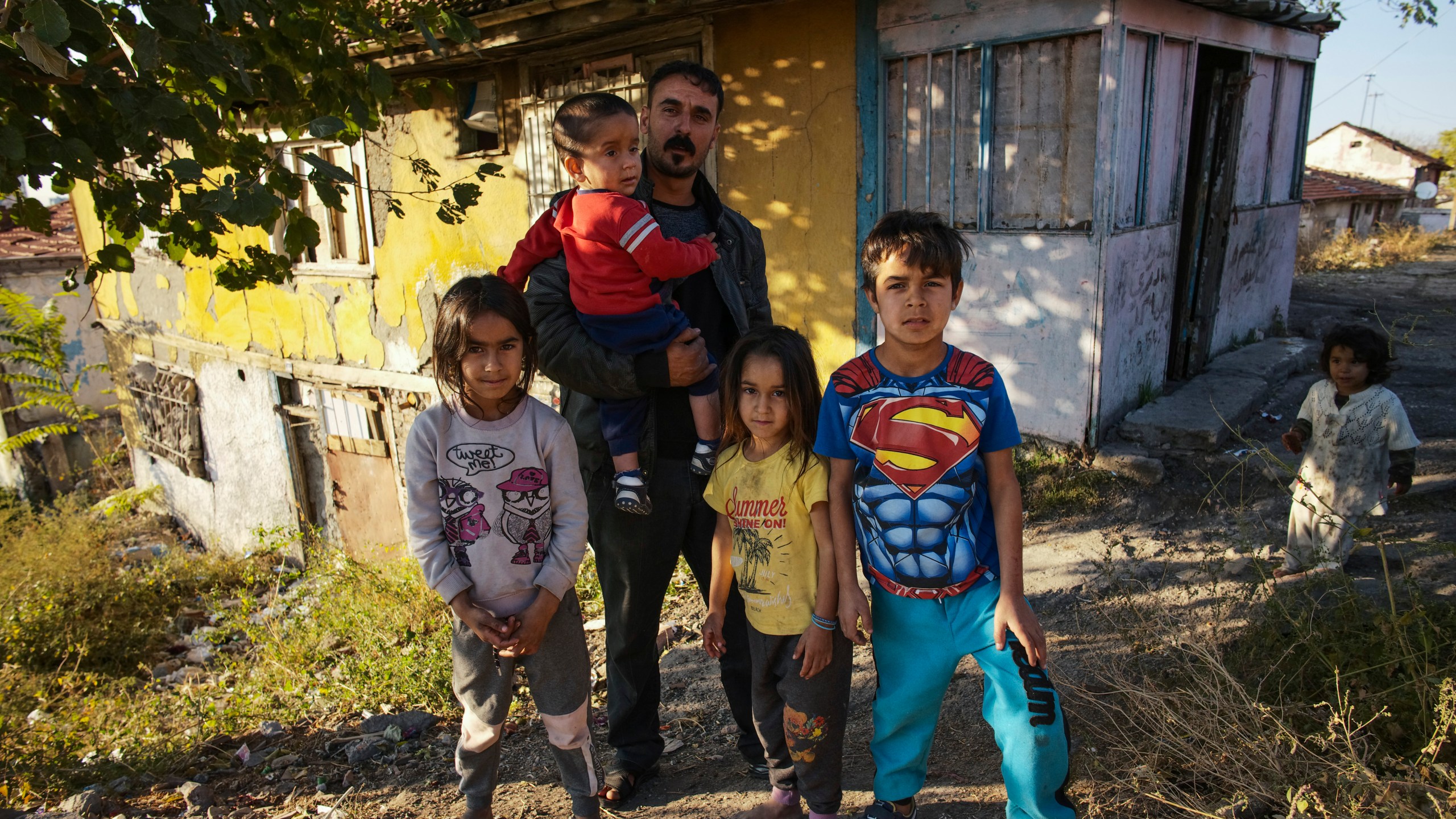 Nidal Jumaa, a Syrian from Aleppo, poses with his children outside their house in a low-income neighbourhood in Ankara, Wednesday, Nov. 9, 2022. Syrians fleeing their country's civil war were once welcomed in Turkey out of compassion, making the country home to the world’s largest refugee community. But as their numbers grew — and as Turkey began to grapple with a battered economy, including skyrocketing food and housing prices — so did calls for their return, with the repatriation of Syrians and other migrants has become a top theme in presidential and parliamentary elections on Sunday, May 14, 2023. (AP Photo/Burhan Ozbilici)