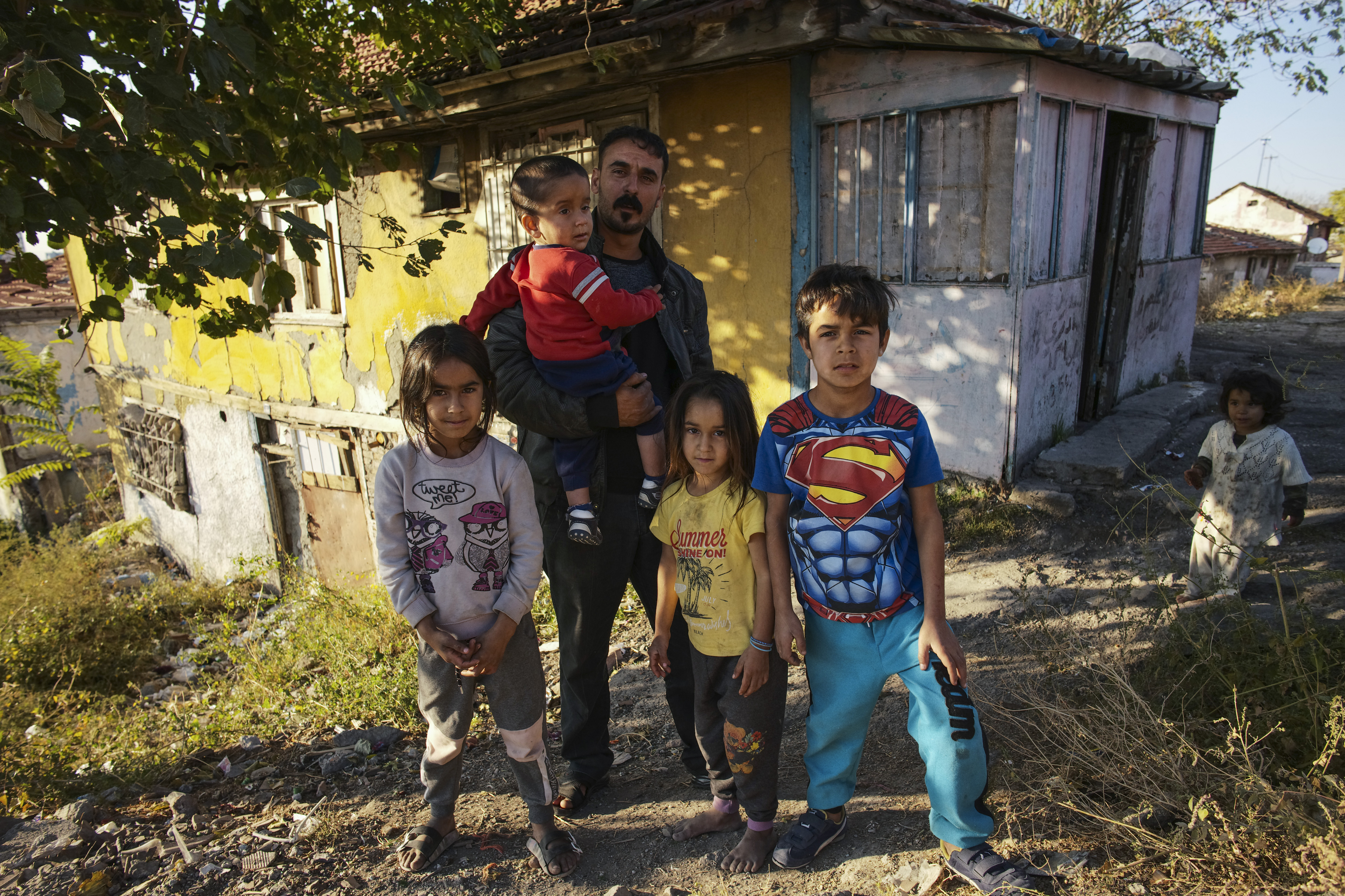 Nidal Jumaa, a Syrian from Aleppo, poses with his children outside their house in a low-income neighbourhood in Ankara, Wednesday, Nov. 9, 2022. Syrians fleeing their country's civil war were once welcomed in Turkey out of compassion, making the country home to the world’s largest refugee community. But as their numbers grew — and as Turkey began to grapple with a battered economy, including skyrocketing food and housing prices — so did calls for their return, with the repatriation of Syrians and other migrants has become a top theme in presidential and parliamentary elections on Sunday, May 14, 2023. (AP Photo/Burhan Ozbilici)