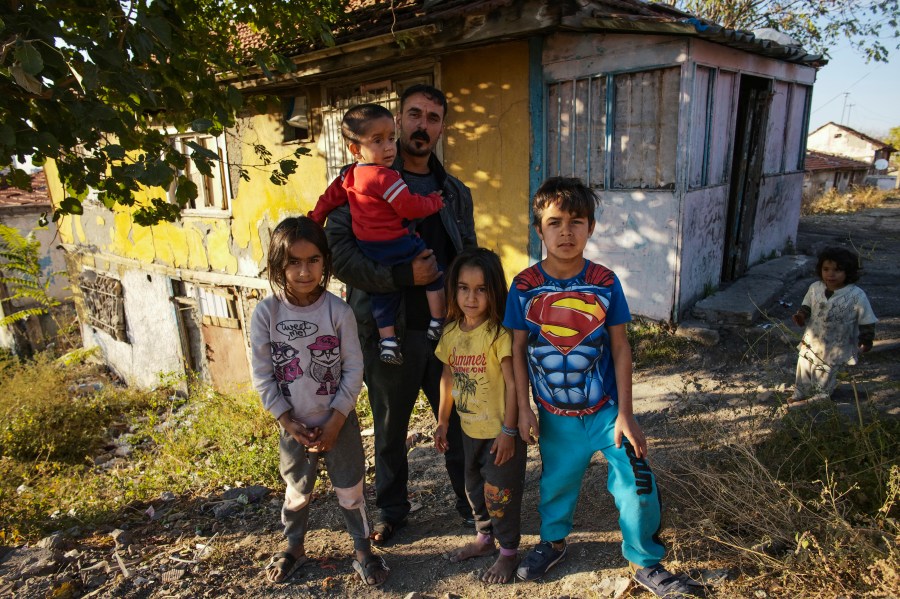 Nidal Jumaa, a Syrian from Aleppo, poses with his children outside their house in a low-income neighbourhood in Ankara, Wednesday, Nov. 9, 2022. Syrians fleeing their country's civil war were once welcomed in Turkey out of compassion, making the country home to the world’s largest refugee community. But as their numbers grew — and as Turkey began to grapple with a battered economy, including skyrocketing food and housing prices — so did calls for their return, with the repatriation of Syrians and other migrants has become a top theme in presidential and parliamentary elections on Sunday, May 14, 2023. (AP Photo/Burhan Ozbilici)