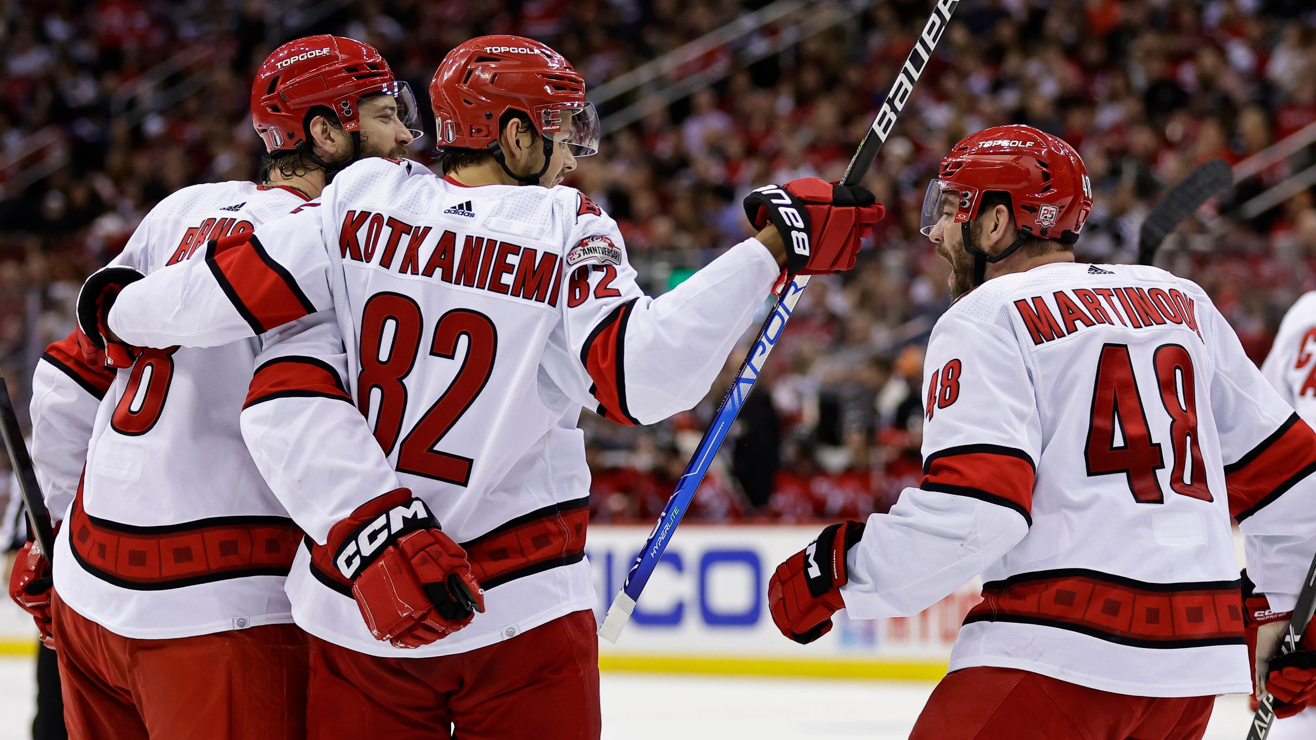 Carolina Hurricanes defenseman Brent Burns is congratulated by Jesperi Kotkaniemi (82) and Jordan Martinook (48) after scoring a goal against the New Jersey Devils during the second period of Game 4 of an NHL hockey Stanley Cup second-round playoff series Tuesday, May 9, 2023, in Newark, N.J. (AP Photo/Adam Hunger)