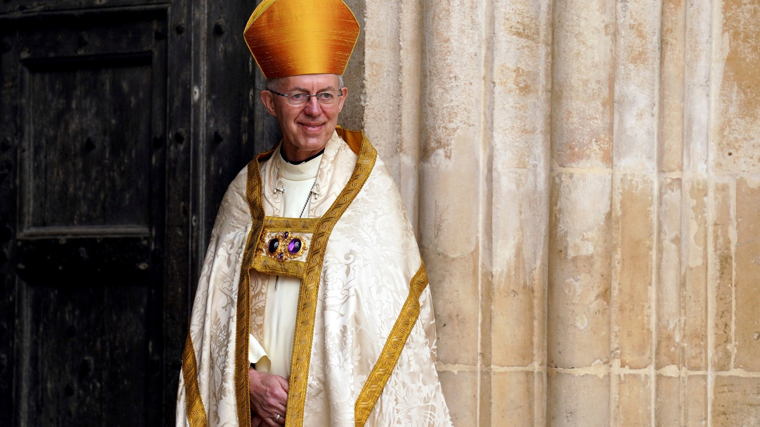 FILE - Archbishop of Canterbury Justin Welby stands at the entrance of Westminster Abbey ahead of the coronation of King Charles III and Camilla, the Queen Consort, in London, Saturday, May 6, 2023. The head of the Church of England on Wednesday, May 10, 2023, condemned a British government bill that would dramatically curb migrants’ ability to seek asylum in the U.K., calling the policy “isolationist, morally unacceptable and politically impractical.” (Andrew Milligan/Pool via AP, File)