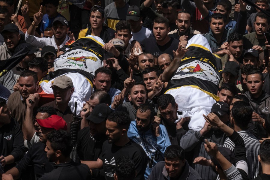 Palestinians carry the bodies of Islamic Jihad commander Ali Ghali, left, and his brother, Mohammed Ghali, both killed in an Israeli airstrike in Khan Younis, southern Gaza Strip, Thursday, May 11, 2023. They are both draped in the Islamic Jihad flag. (AP Photo/Fatima Shbair)