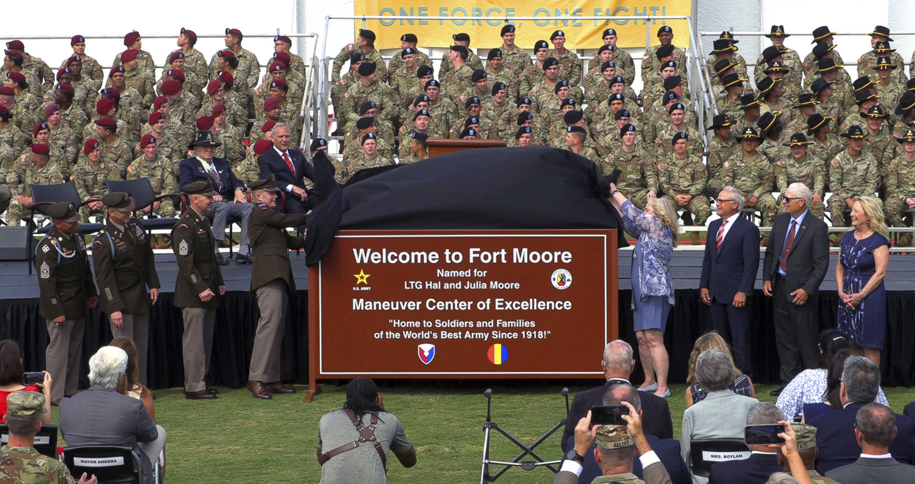 The children of Lt. Gen. Hal and Julia Moore join the command team at what's now Fort Moore during the unveiling the new sign, Thursday morning, May 11, 2023, at Doughboy Stadium in Fort Moore, Ga. The Army's training hub in Georgia was renamed Fort Moore from Fort Benning during a ceremony Thursday, replacing the name of a Confederate officer that had adorned the base for more than a century with that of a decorated Vietnam War commander and his wife. (Mike Haskey/Ledger-Enquirer via AP)