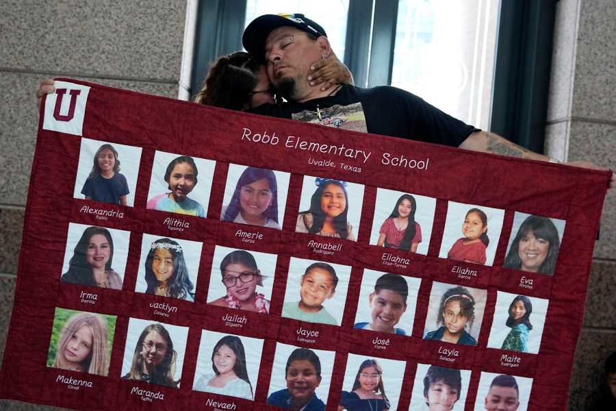 Abel Lopez, right, father of Xavier Lopez who was killed in the shootings in Uvalde, Texas, holds a banner honoring the victims after a Texas House committee voted to take up a bill to limit the age for purchasing AR-15 style weapons in the full House in Austin, Texas, Monday, May 8, 2023. (AP Photo/Eric Gay)