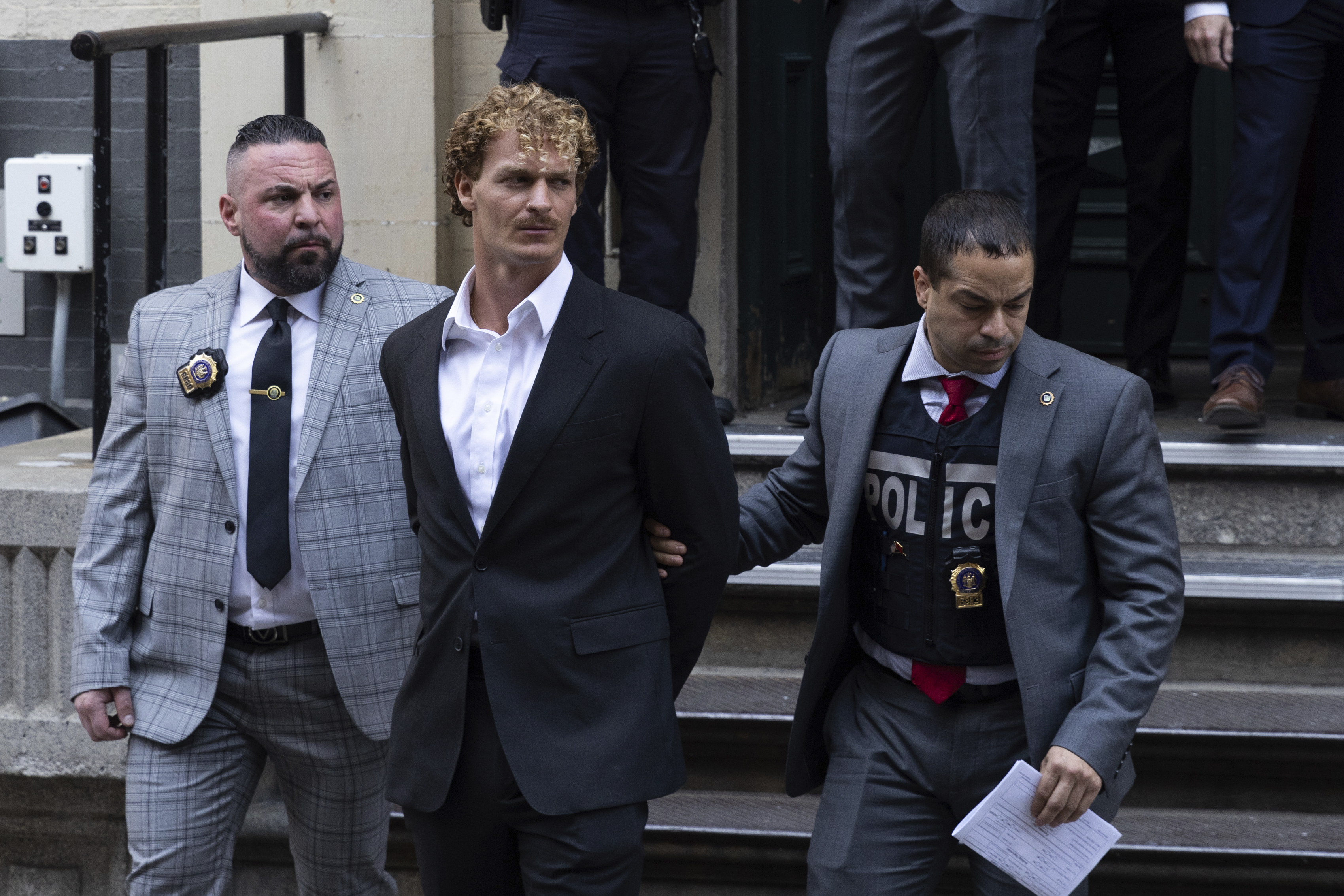 Daniel Penny, center, is walked by New York Police Department detectives detectives out of the 5th Precinct on Friday, May. 12, 2023 in New York. Manhattan prosecutors announced Thursday they would bring the criminal charge against Penny, 24, a U.S. Marine Corps veteran, in the May 1 death of 30-year-old Jordan Neely. (AP Photo/Jeenah Moon)