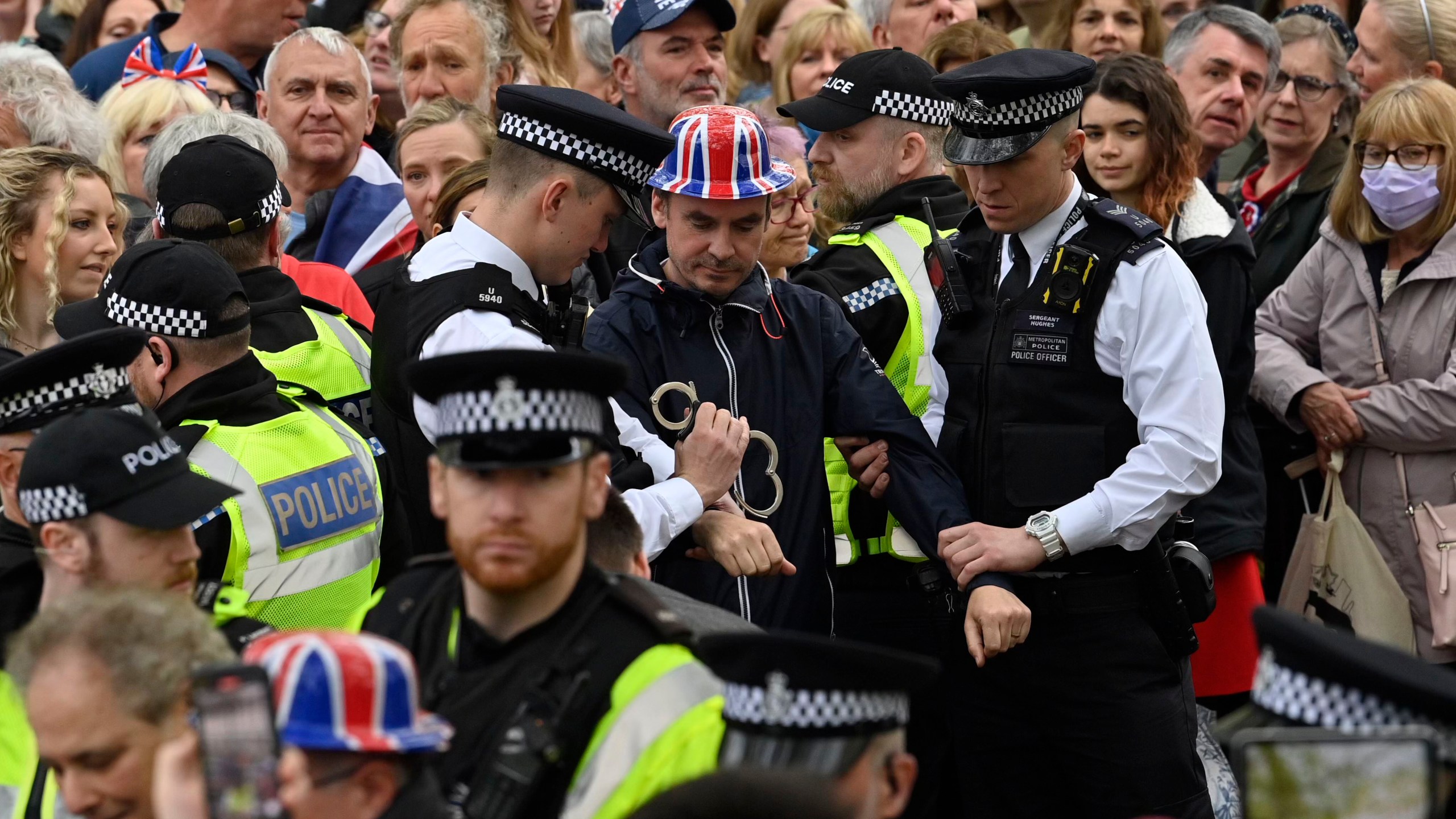 FILE - Protesters from climate protest group 'Just Stop Oil' are apprehended by police officers in the crowd close to where Britain's King Charles III will be crowned at Westminster Abbey, in London, Saturday, May 6, 2023. London’s top police officer on Friday, May 12, 2023 defended the department against complaints of a heavy-handed response to protesters during the coronation of King Charles III, saying his officers intervened to prevent “serious disruption and criminality.” (Justin Tallis/Pool Photo via AP, File)