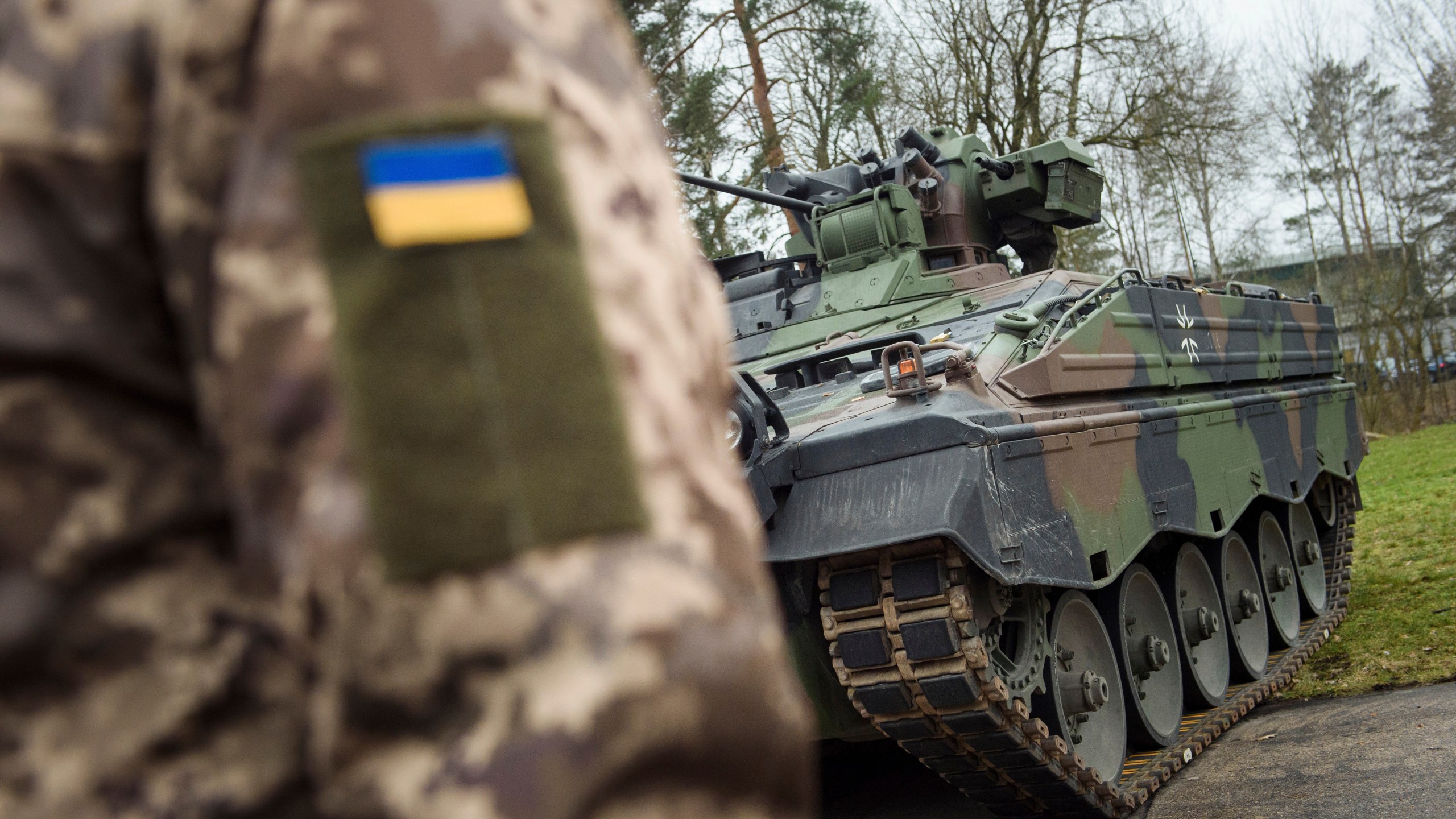 FILE - A Ukrainian soldier is standing in front of a Marder infantry fighting vehicle at the German forces Bundeswehr training area in Munster, Germany, Monday, Feb. 20, 2023. Germany said Saturday, May 13, 2023 it is providing Ukraine with additional military aid worth more than 2.7 billion euros ($3 billion), including tanks, anti-aircraft systems and ammunition. The announcement Saturday came as preparations were underway in Berlin for a possible first visit to Germany by Ukrainian President Volodymyr Zelenskyy since Russia invaded his country last year. (AP Photo/Gregor Fischer, File)