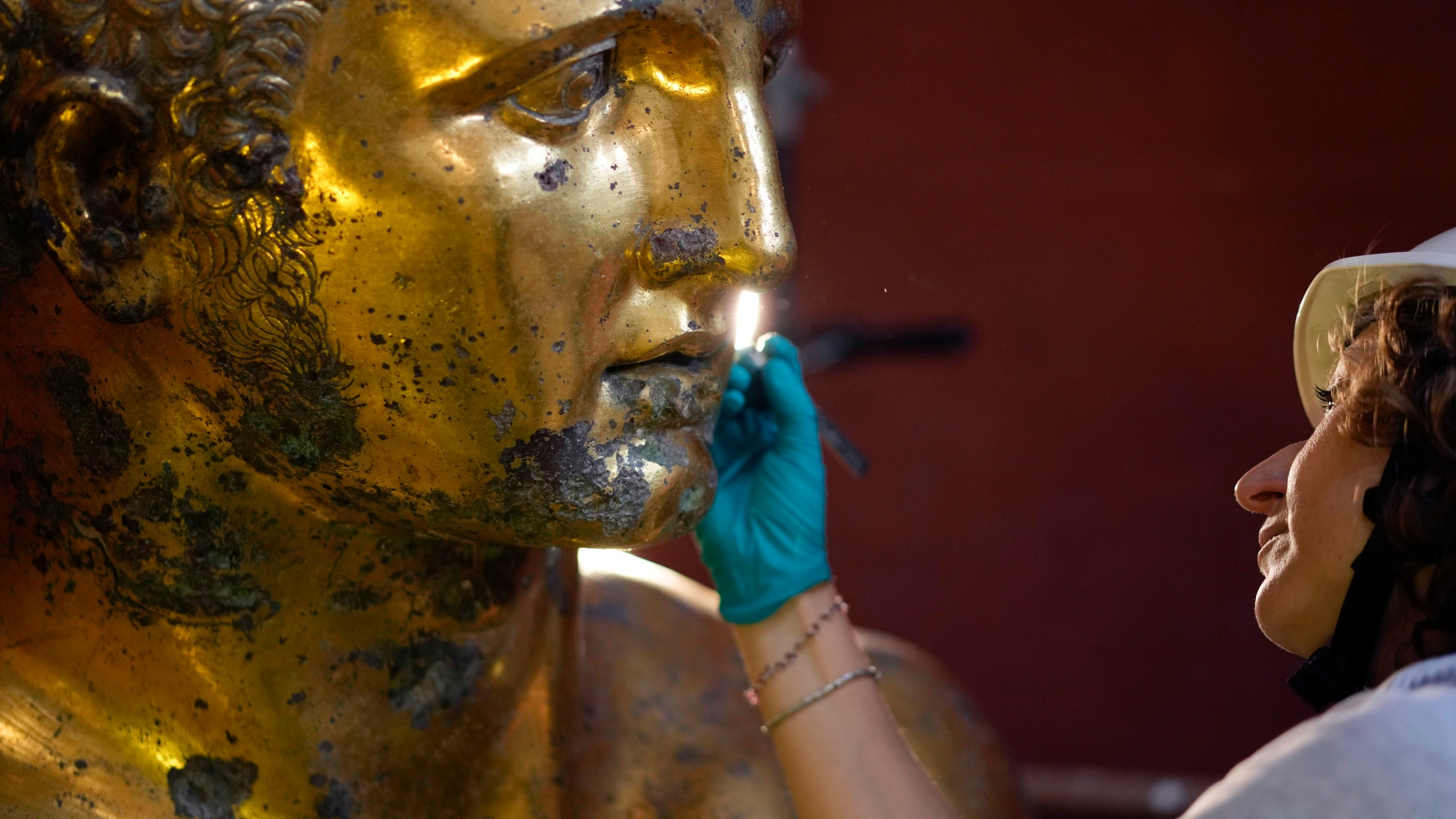 Vatican Museum restorer Alice Baltera works on the bronze Hercules statue, in the Round Hall of the Vatican Museums, Thursday, May 11, 2023. Work will continue until December to reveal the 4-meter- (13-foot-) tall Hercules, believed to have stood in ancient Rome’s Pompey Theater, to its original golden sheen. The discovery of the gilded bronze in 1864 during work on a banker’s villa near Piazza dei Fiori made global headlines. (AP Photo/Andrew Medichini)