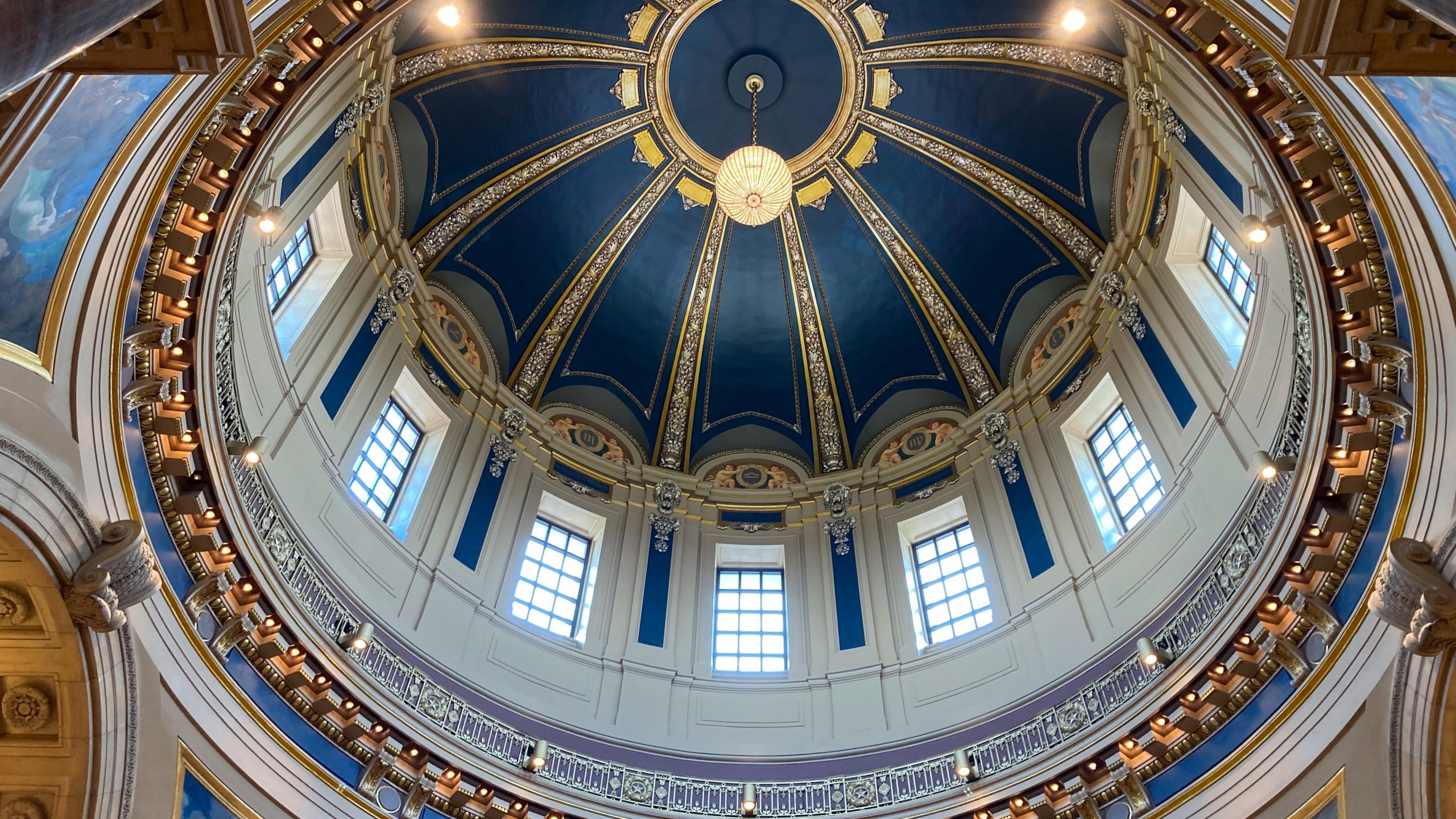 The "electrolier" is lit in the Minnesota State Capitol dome in St. Paul, Minn., Thursday, May 11, 2023, to mark Statehood Day, Minnesota's 165th birthday. The electrolier," an old term for "electric chandelier," is over 100 years old, dating from when electricity was new. It measures 6 feet in diameter, contains 92 light bulbs and hangs over 140 feet above the floor in the Capitol Rotunda. It's lit only on special occasions, such as the annual Statehood Day or on the first days of legislative sessions. (AP Photo/Steve Karnowski)